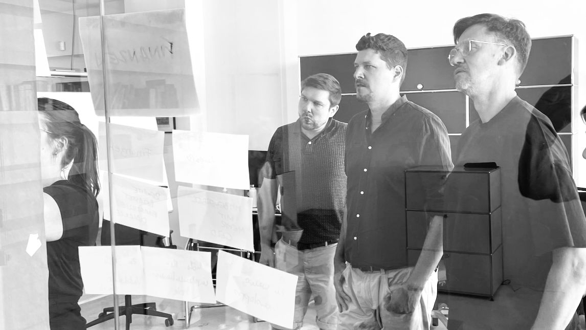 Foto aus einem Workshop. Nora heftet Notizzettel an ein Board.