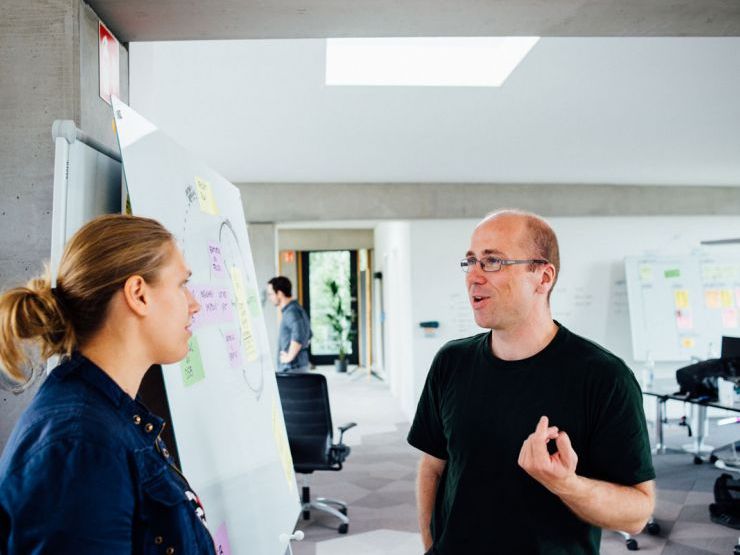 Bild zweier Mitarbeiter an einem Whiteboard