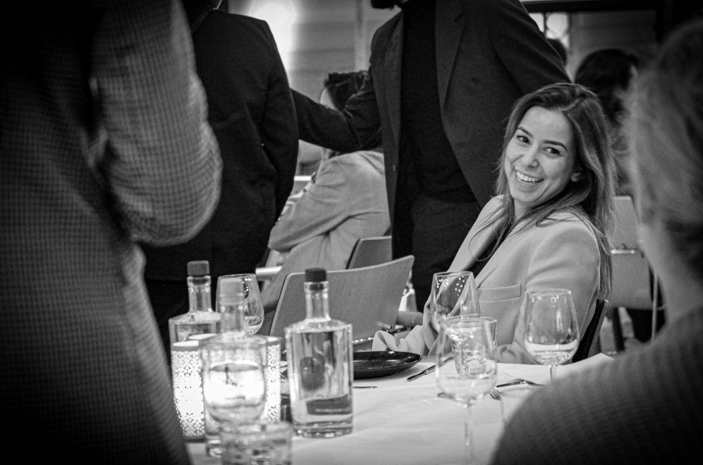 Vrouw lachend aan een dinertafel