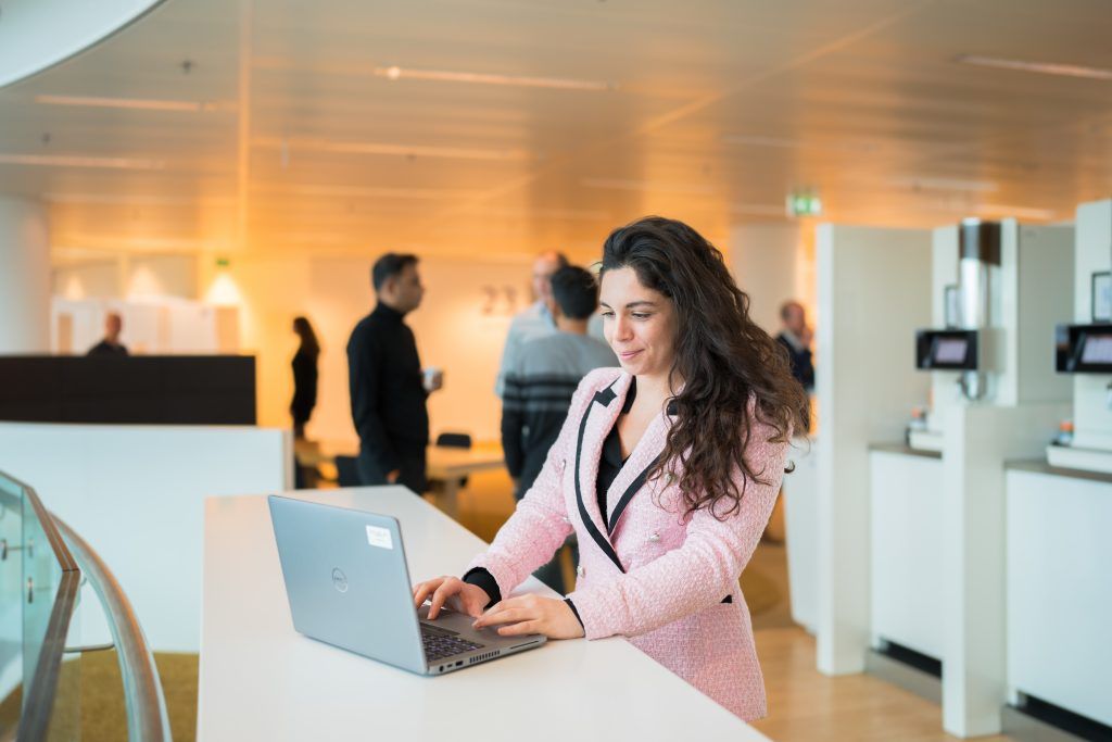 Young female professional is standing outside in front of Rabobank office