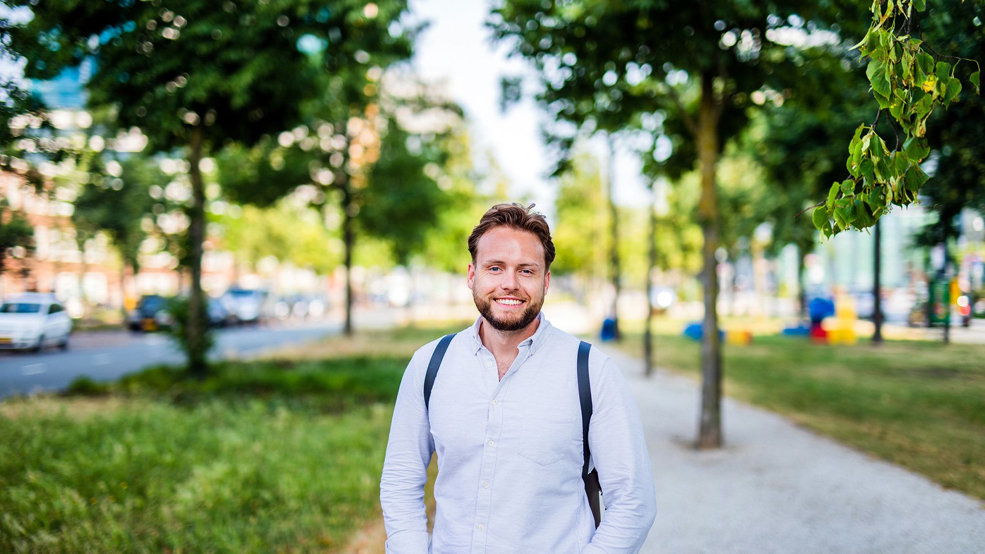 Jonge man kijkt lachend in de camera