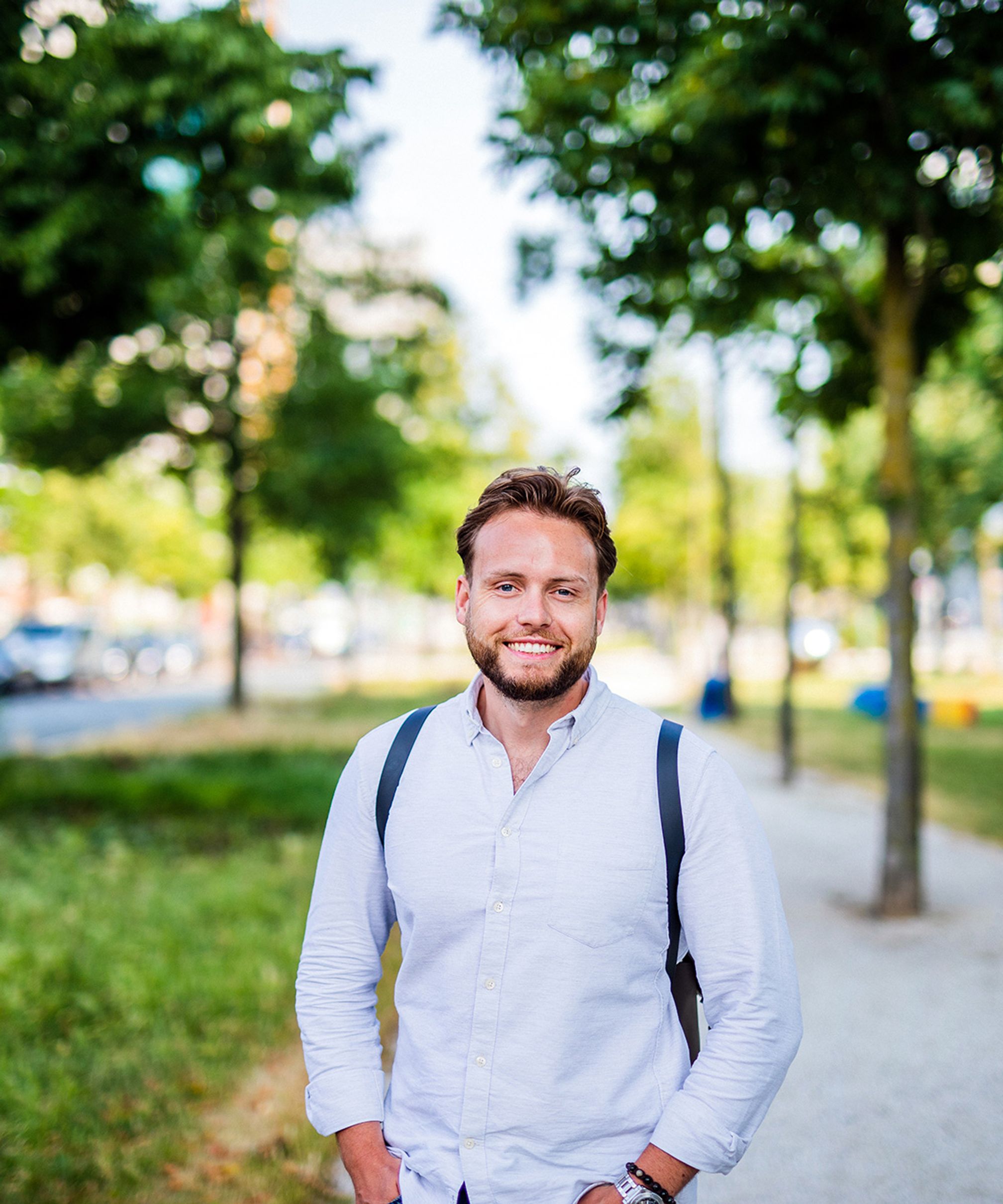 Young man smiling in park.
