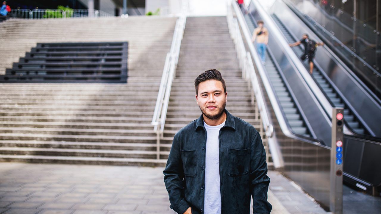 Jonge man staat buiten voor een grote trap