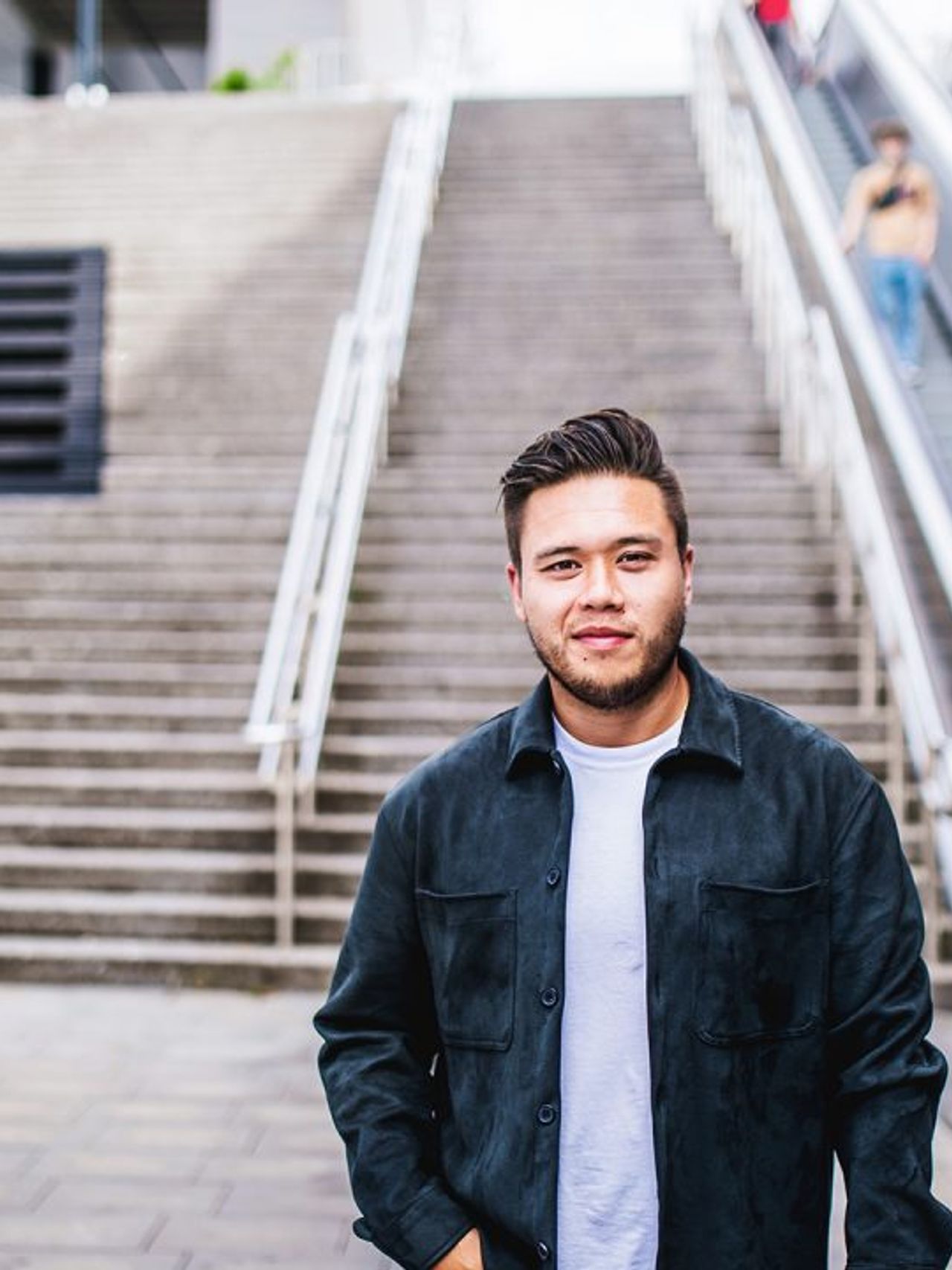Jonge man staat buiten voor een grote trap