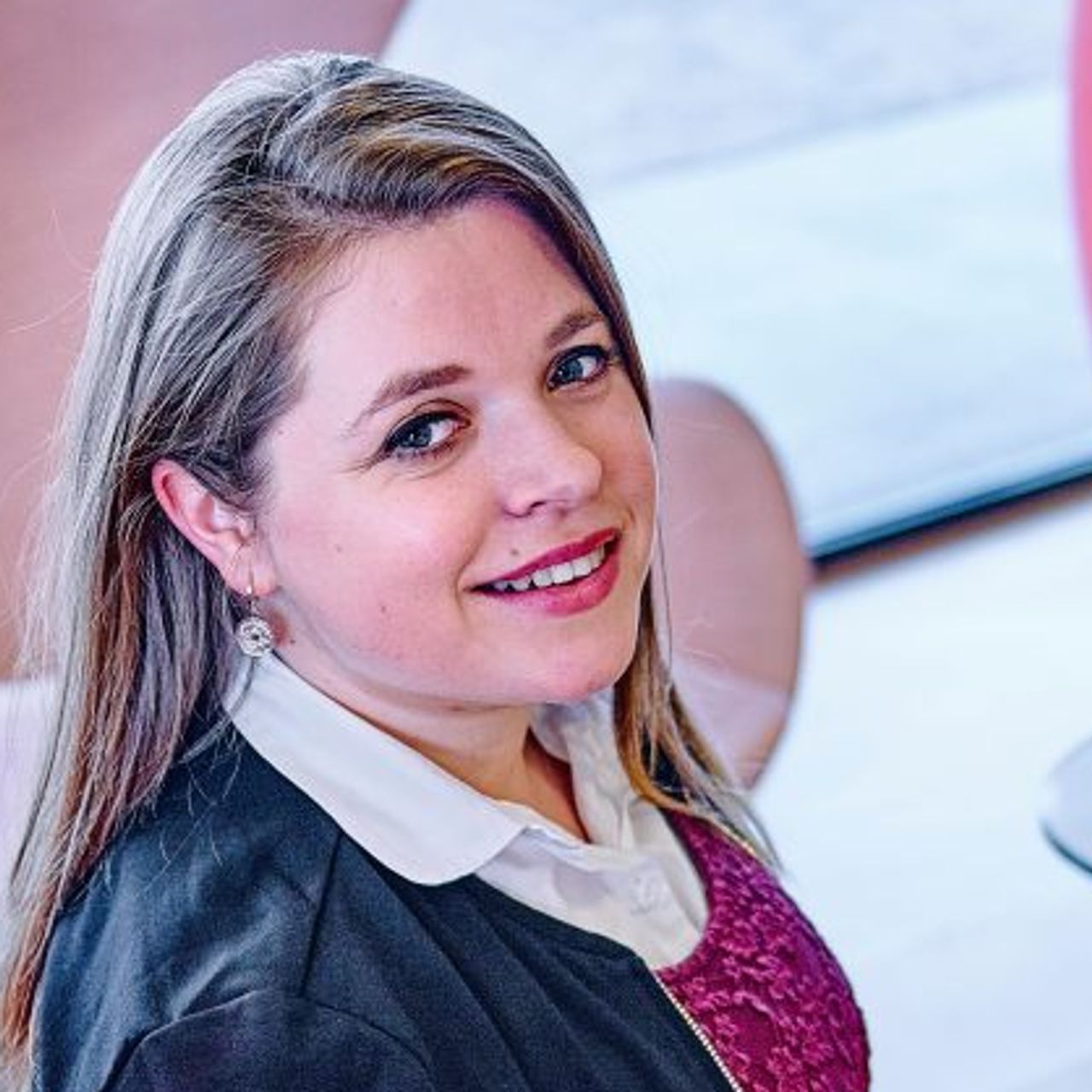 Sophie kijkt over haar schouder vanuit een stoel in de camera