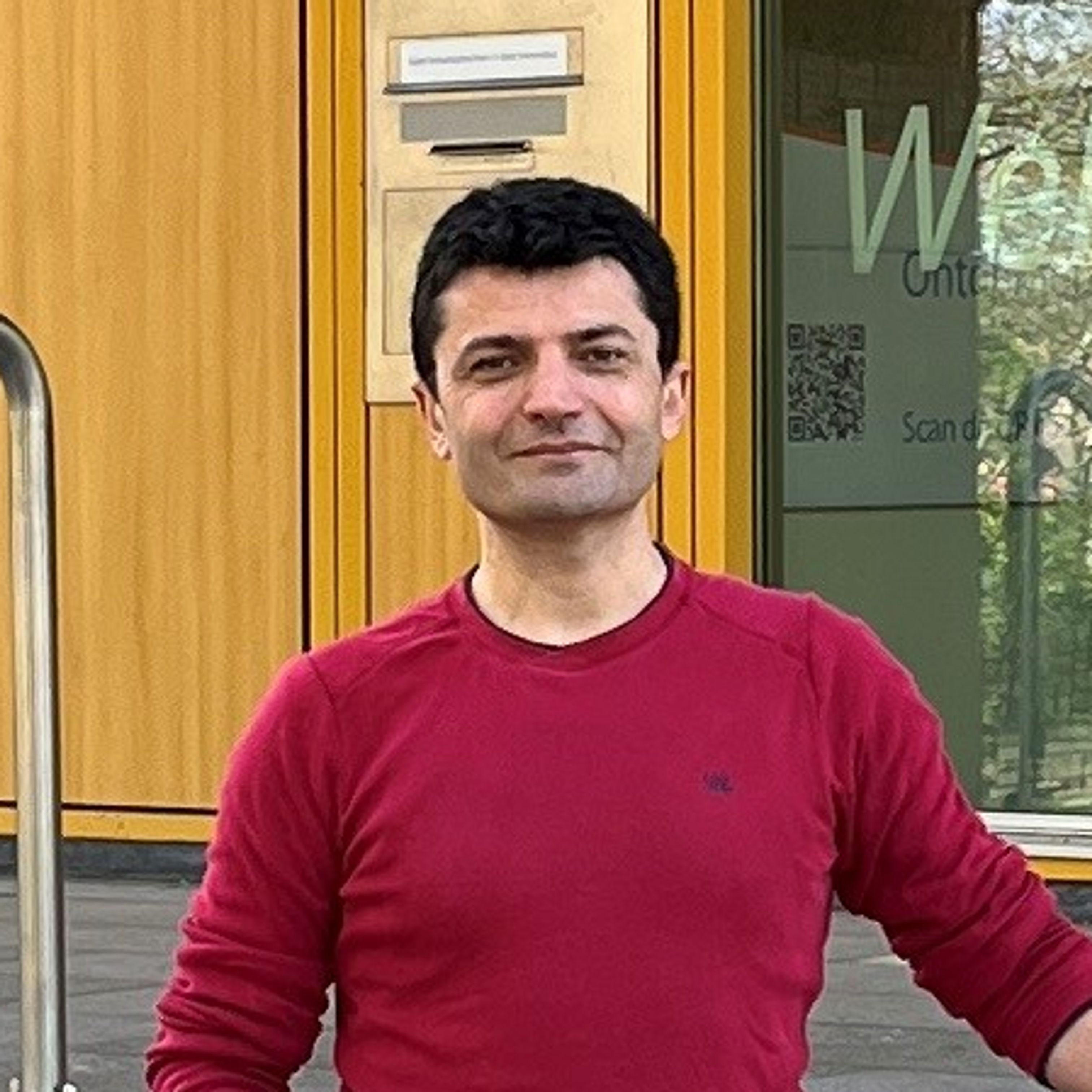 Serdar in front of a Rabobank office