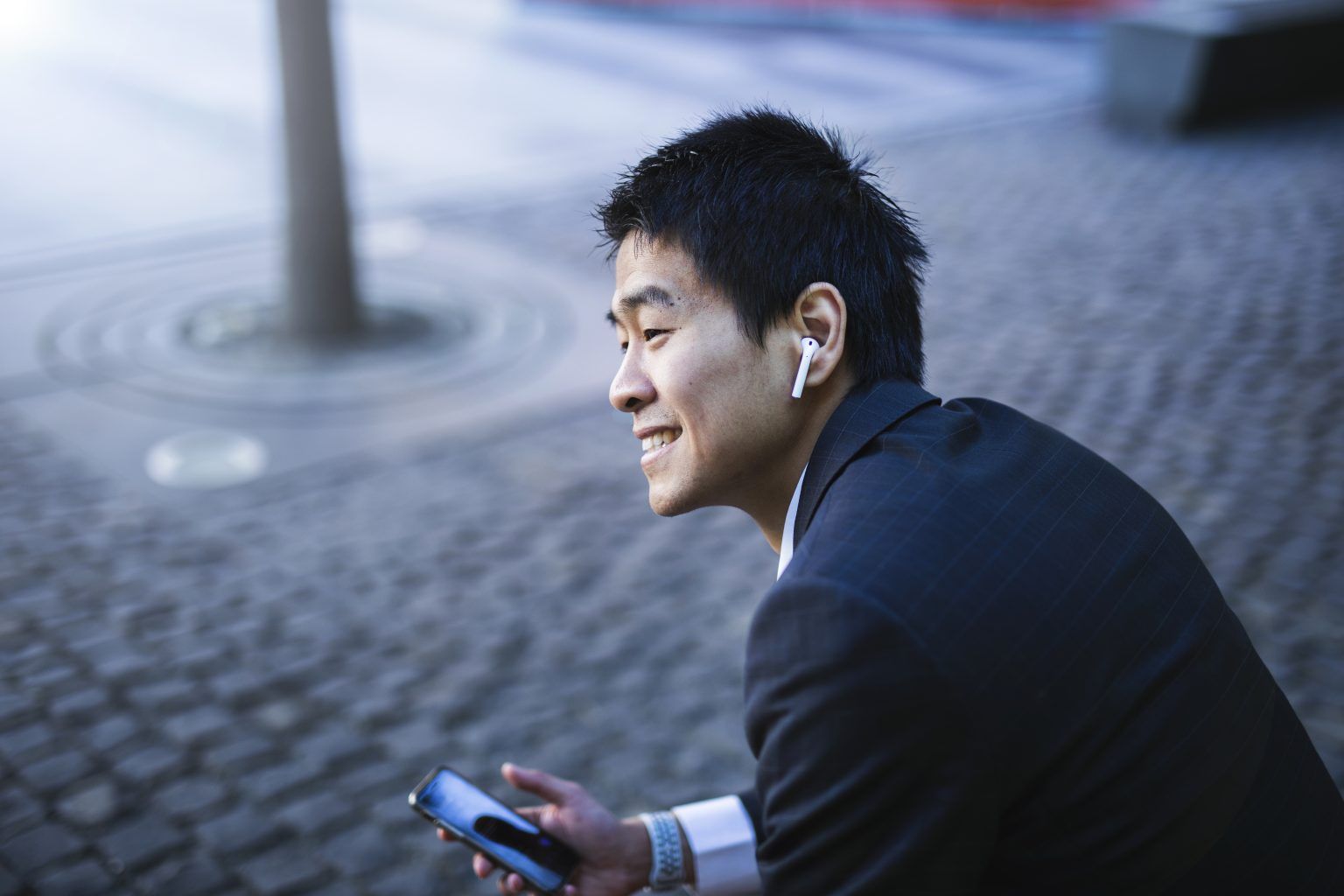 Man met oordopjes in, heeft telefoongesprek