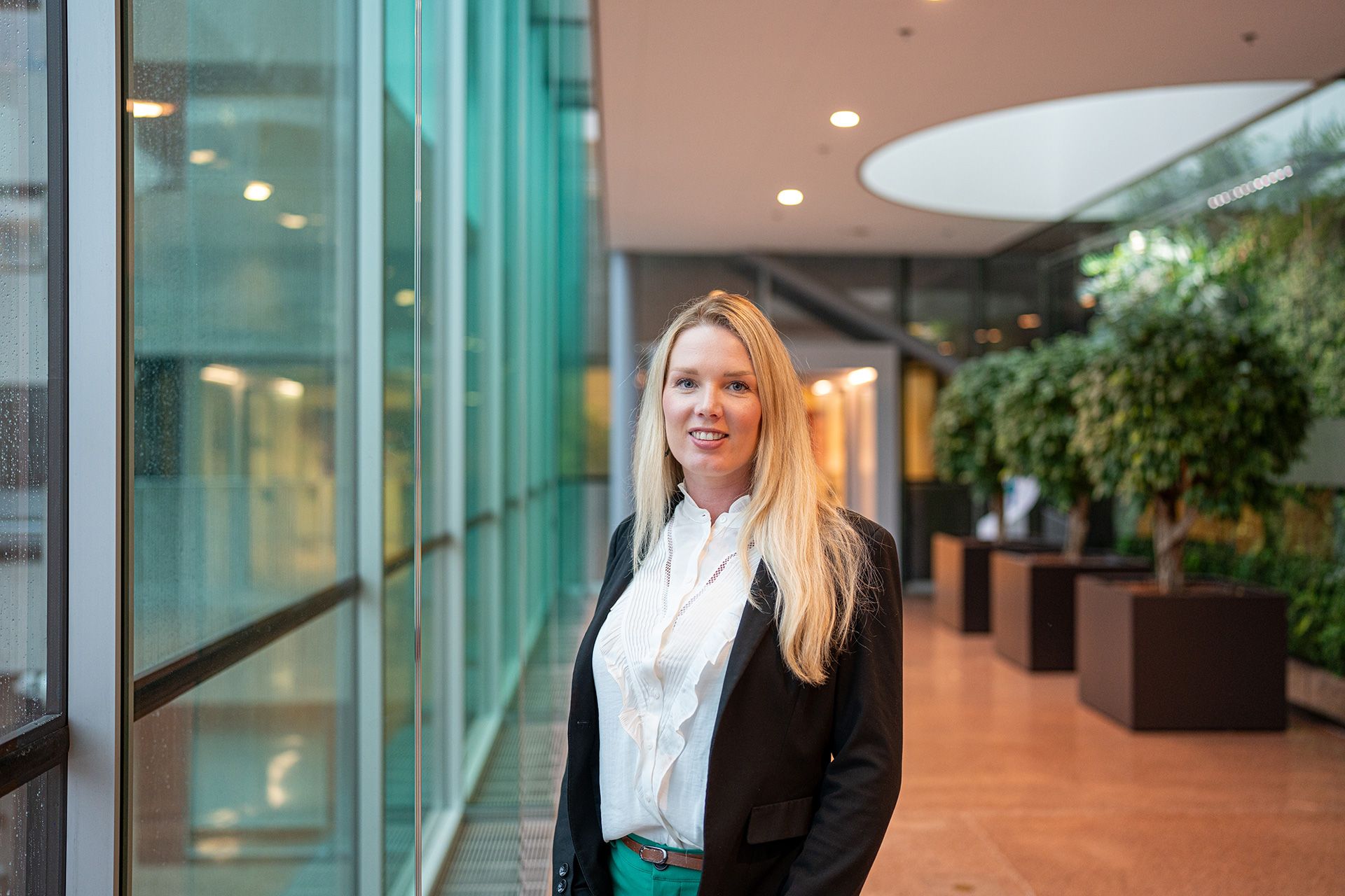Stephanie Vrolijk (Transaction Banker) naast glazen wand.