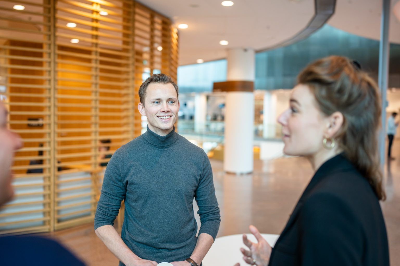 Young professional in gesprek met collega's 