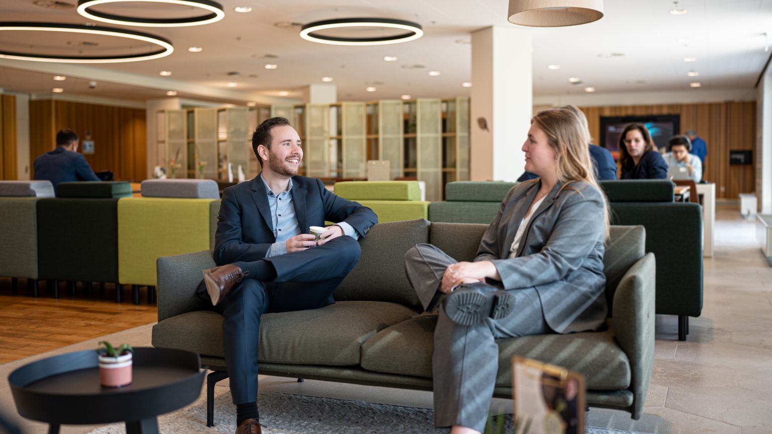 twee collega's zitten op een bank en lachen