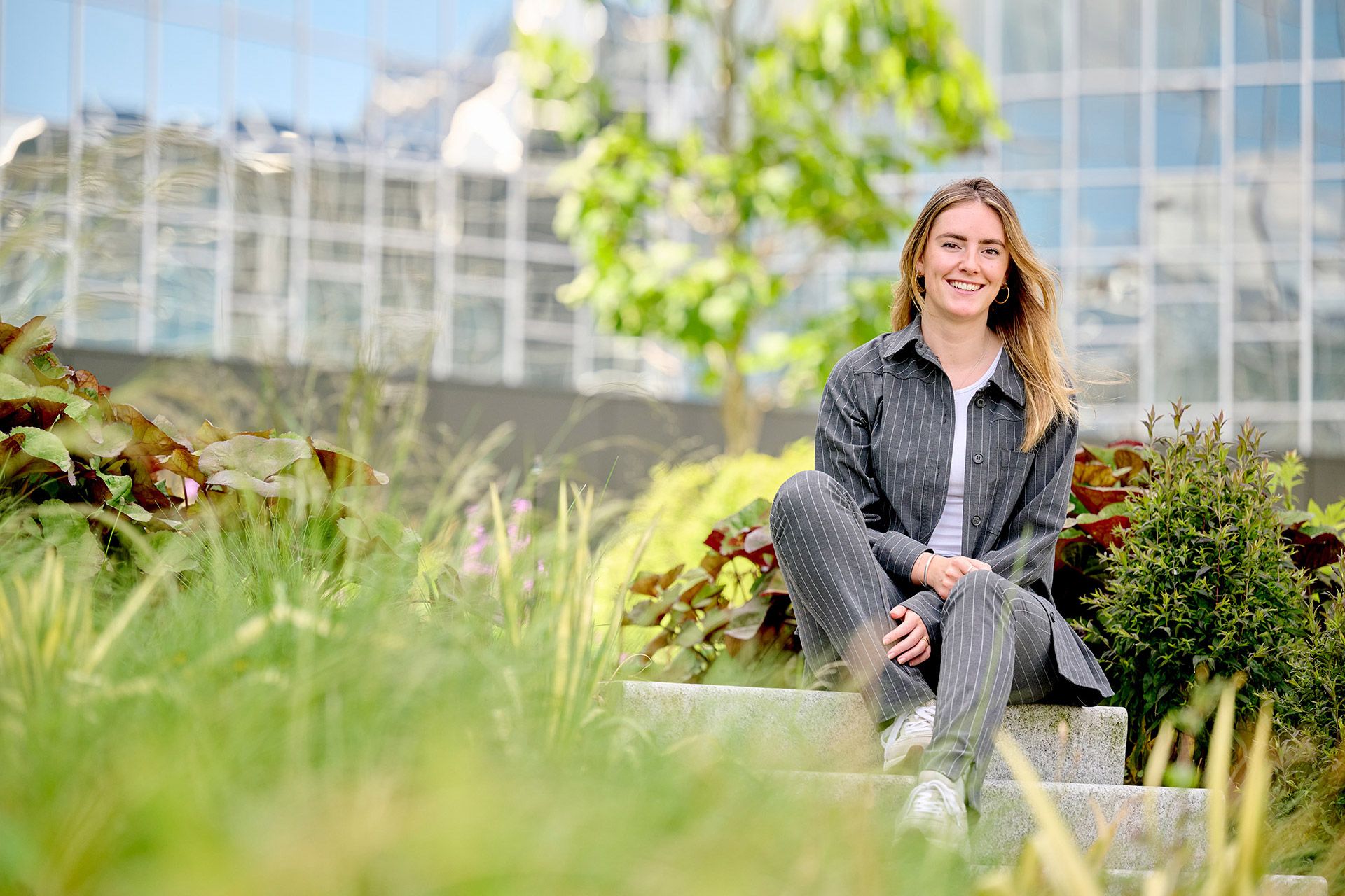 Vrouwelijke young professional zittend op trap in tuin