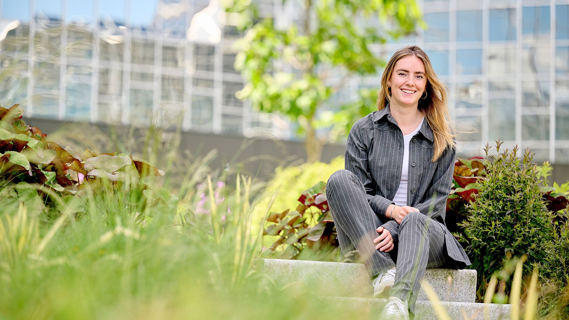 Vrouwelijke young professional zittend op trap in tuin