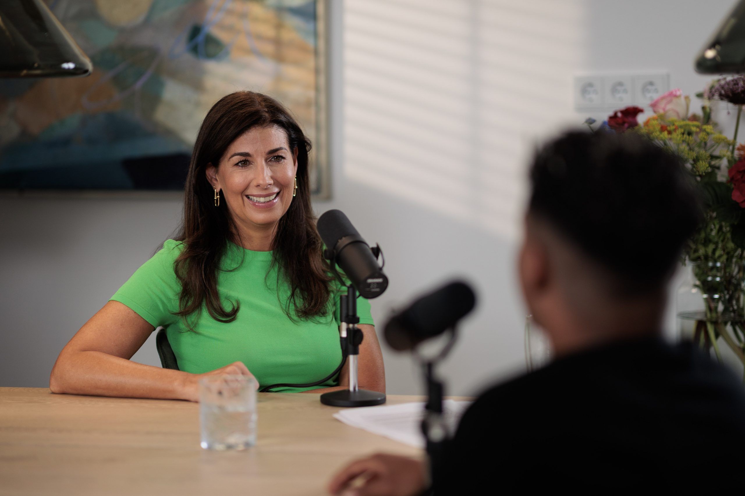 Janine Vos achter podcastmicrofoon.