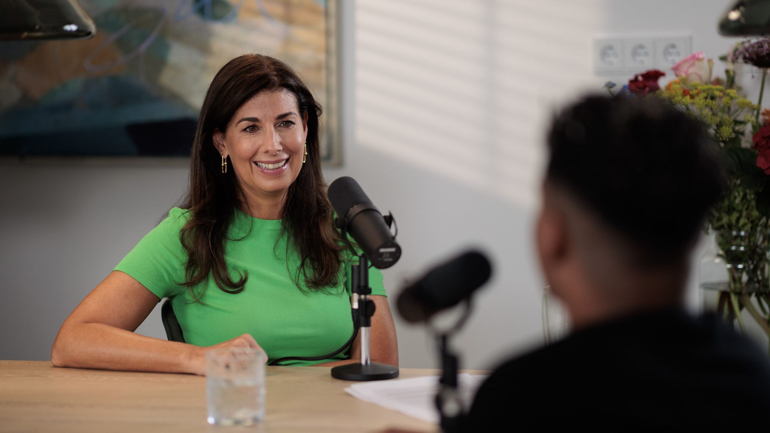 Janine Vos achter podcastmicrofoon.