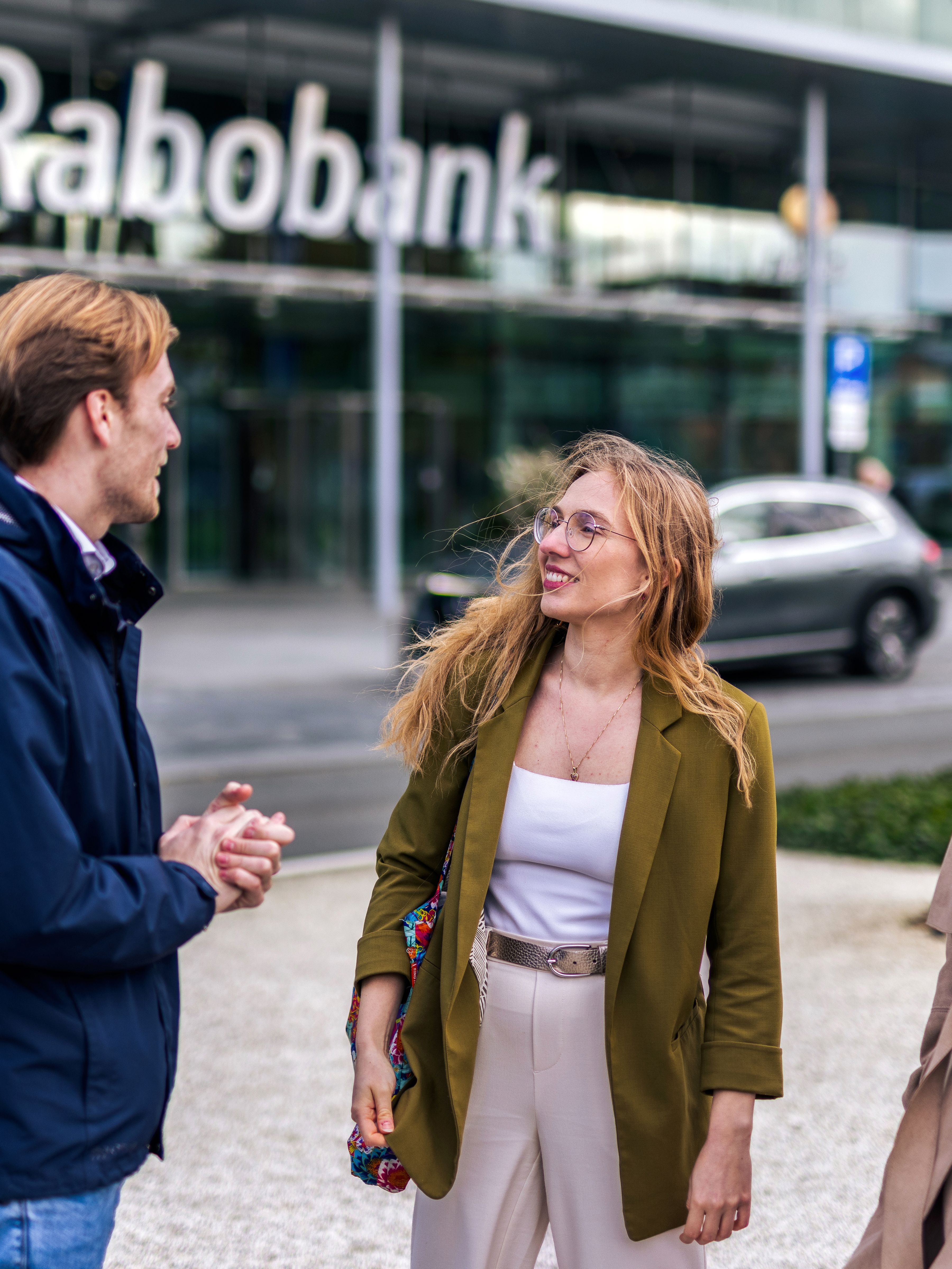 Three colleagues are standing in front of Rabobank office