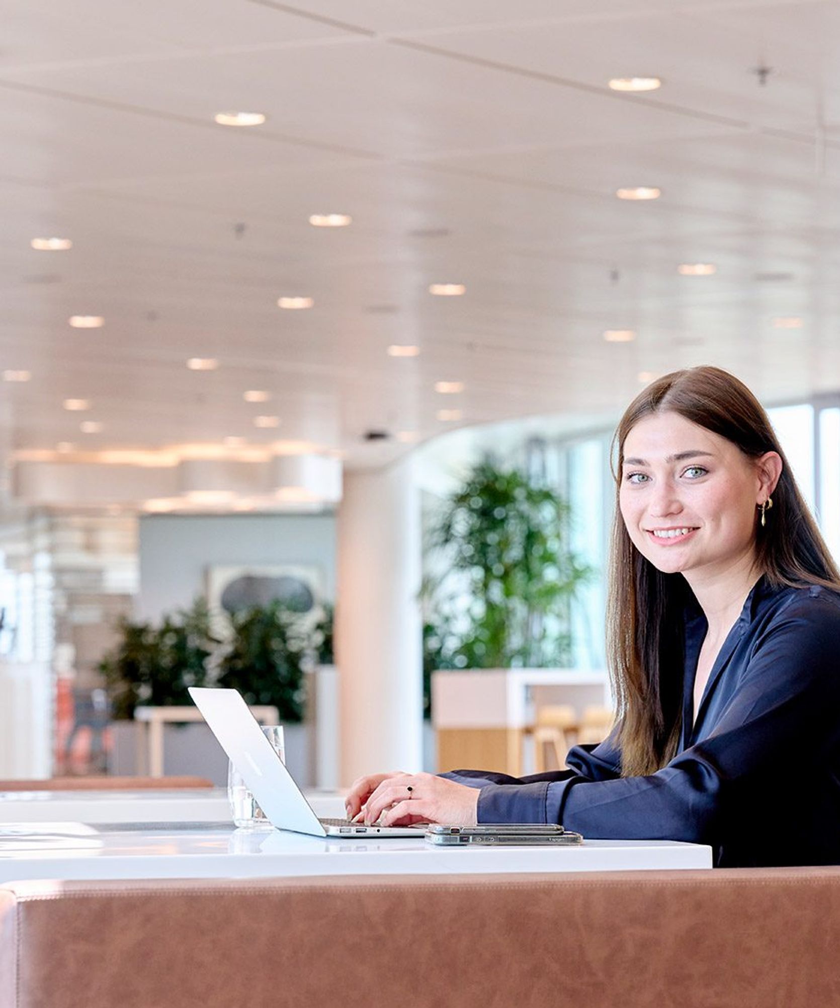 Young woman smiling behind her laptop