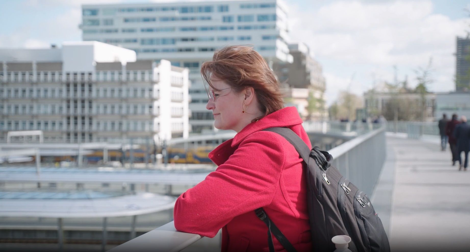 Vrouw staat op brug en kijkt voor zich uit