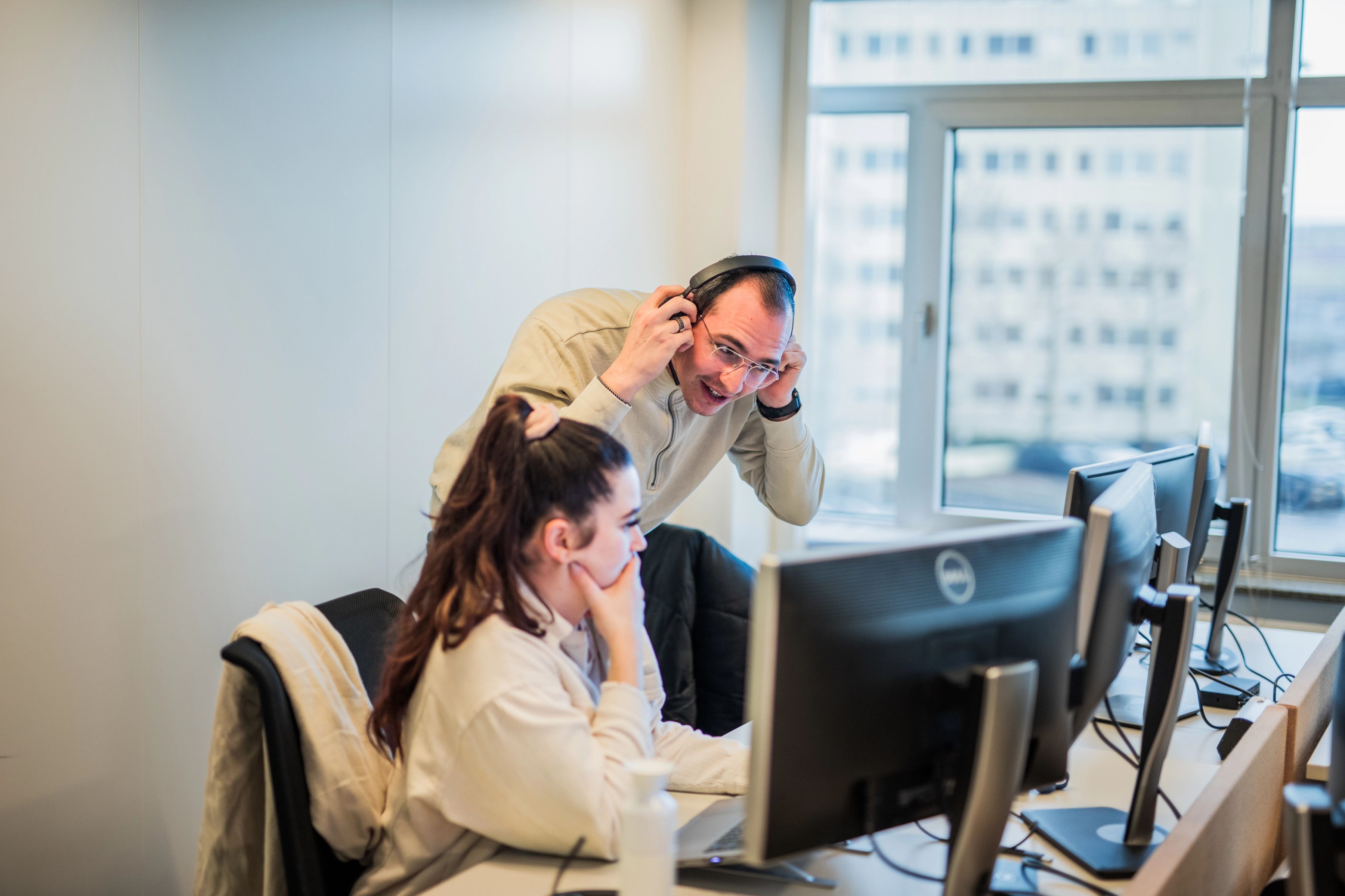 Two colleagues working behind a screen