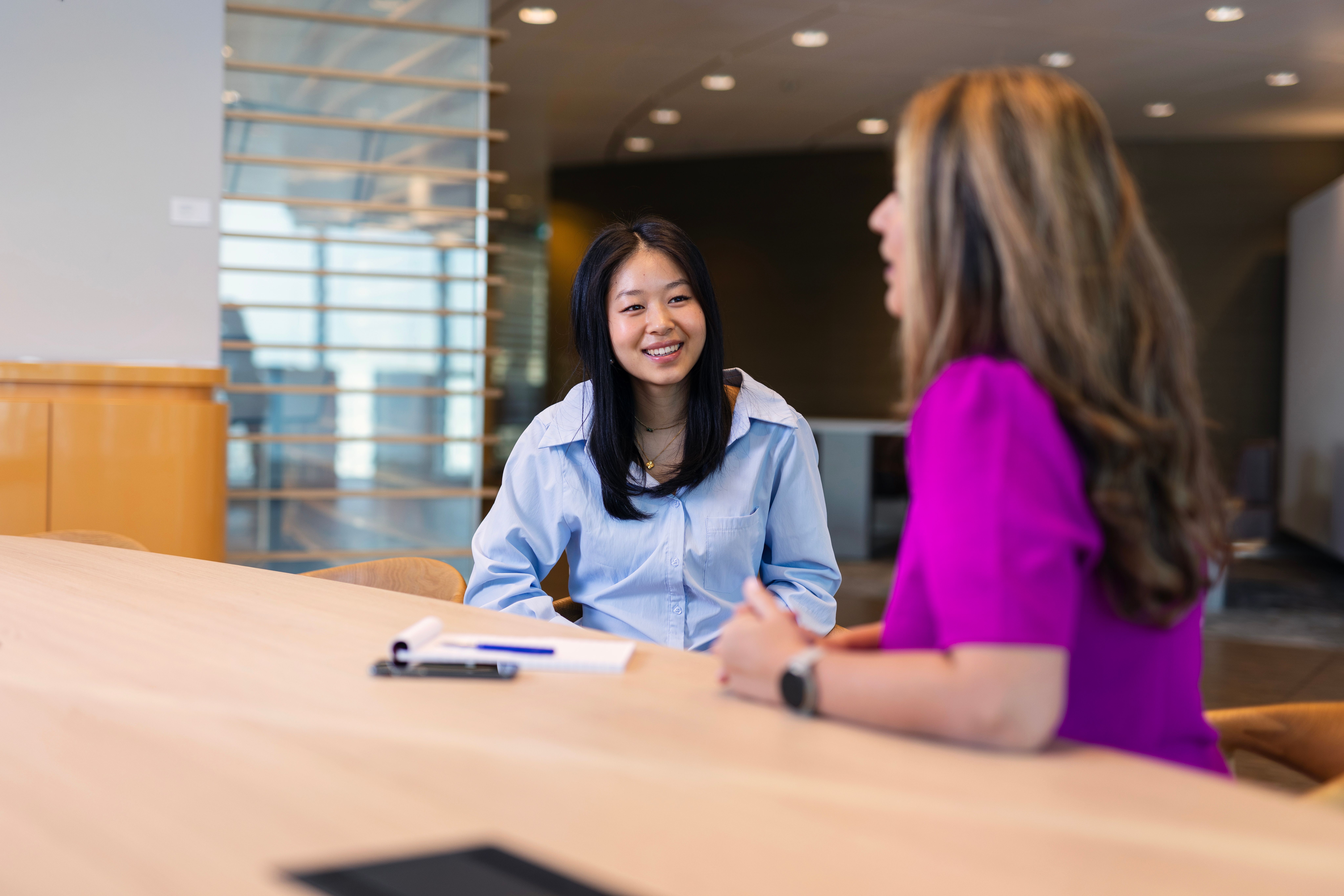 Lachende vrouw op kantoor in gesprek