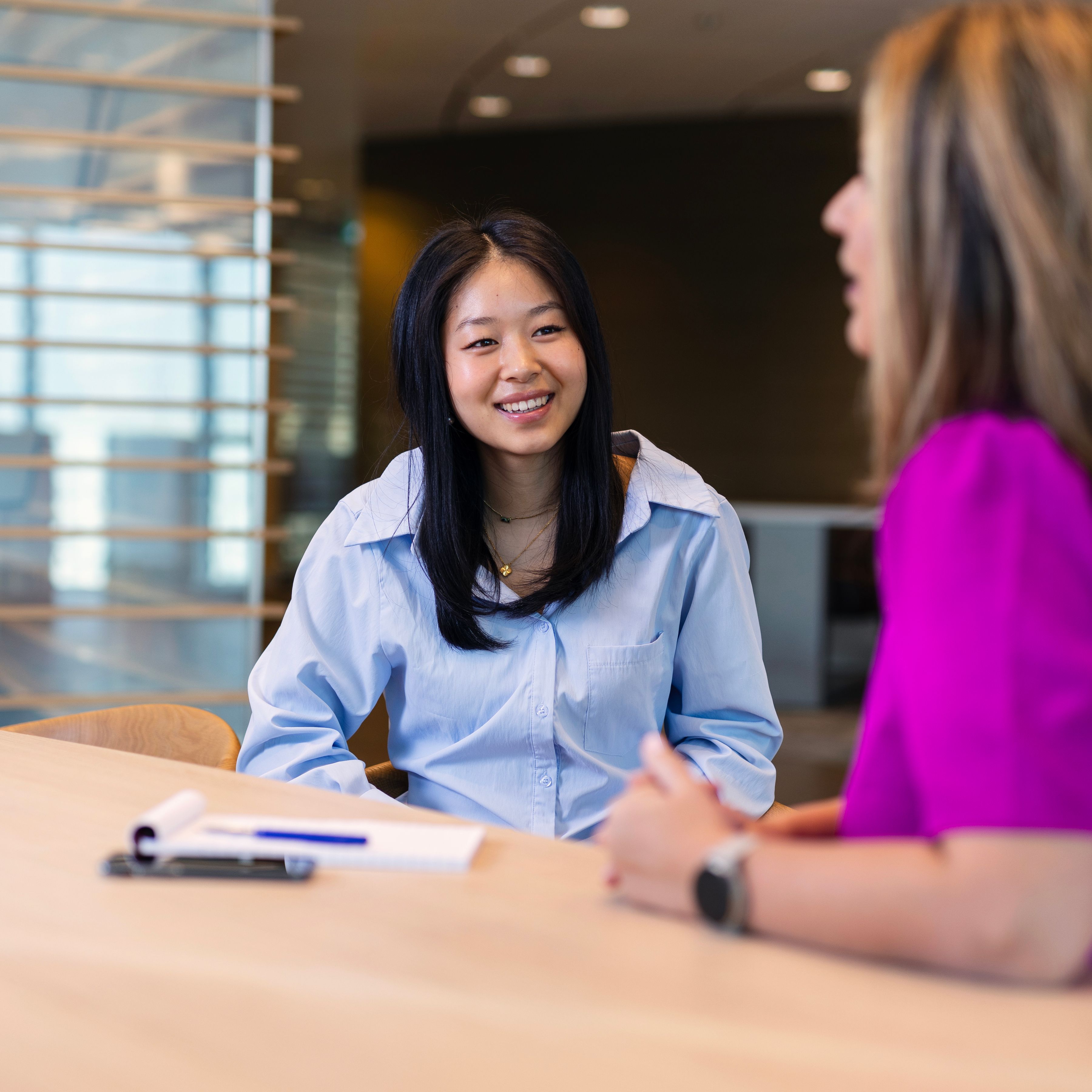 Lachende vrouw op kantoor in gesprek