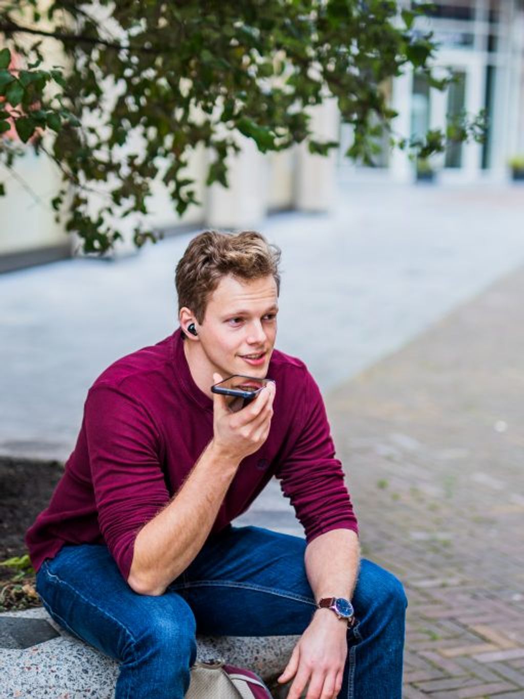 Young man outside talking on the phone.