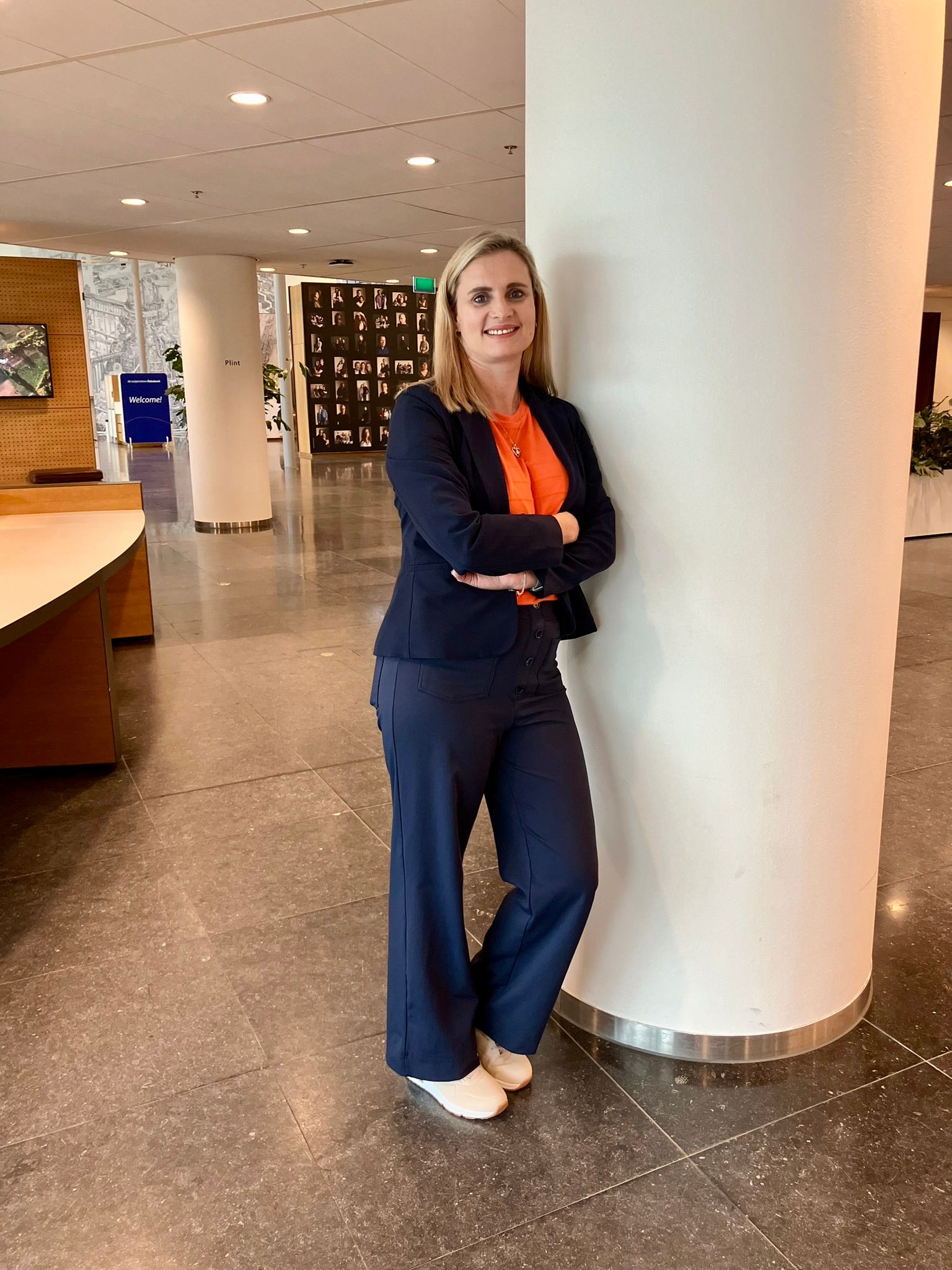 woman wearing a blue suit with an orange blouse 