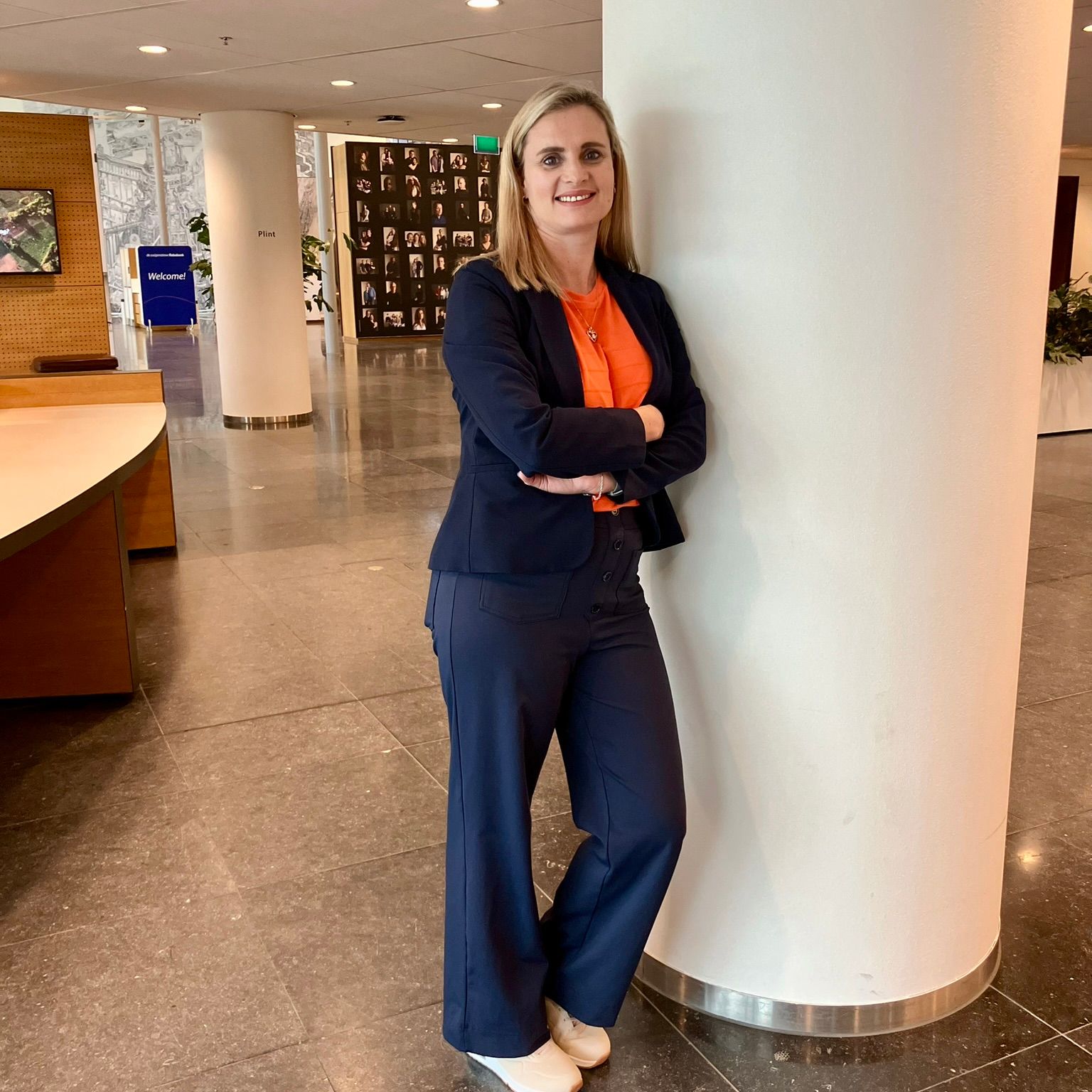woman wearing a blue suit with an orange blouse