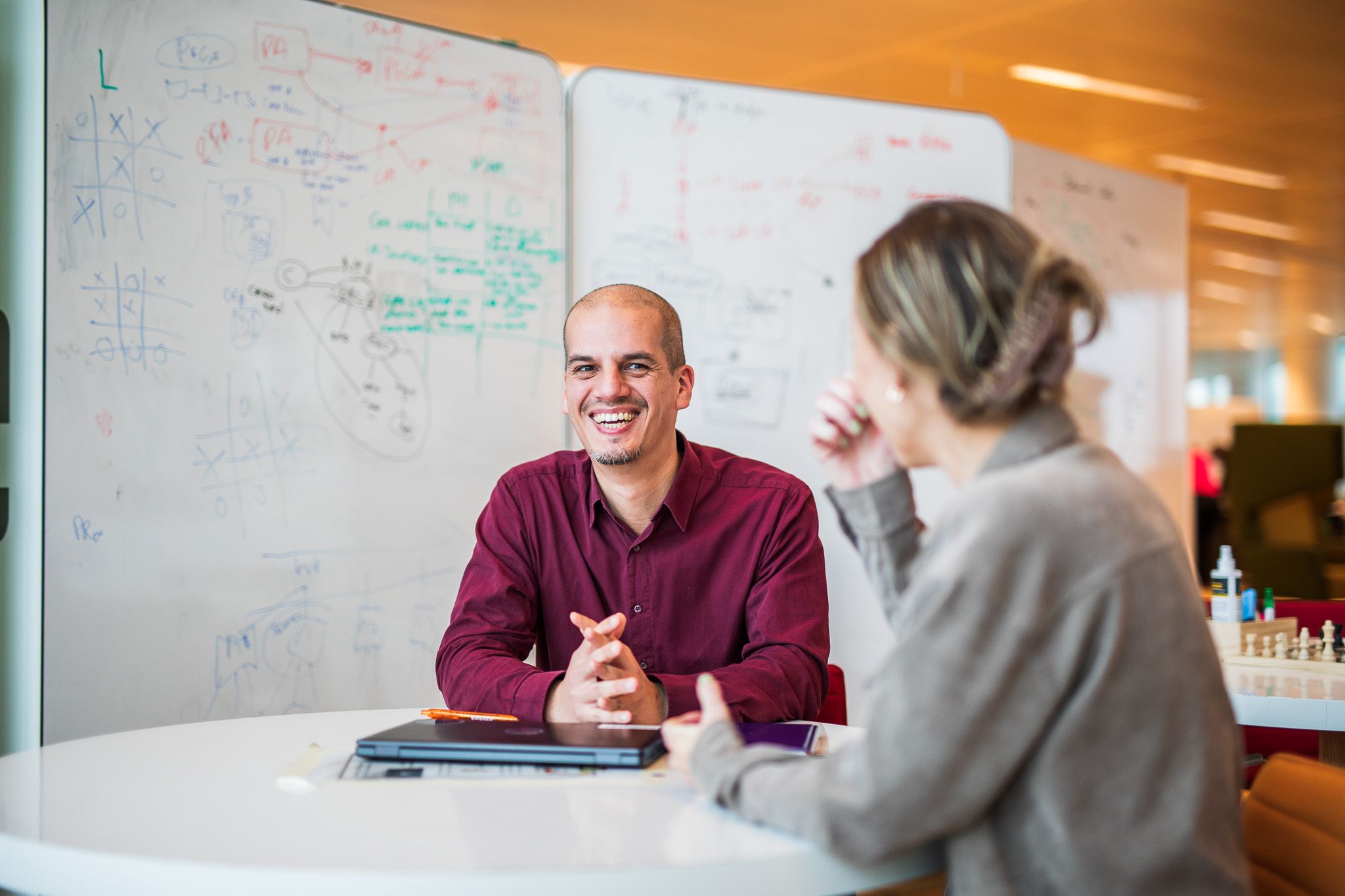 Man smiling in front of whiteboard