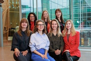 A group of women of the Rabo Women* in Tech community posing for a photo in a Rabobank office building  