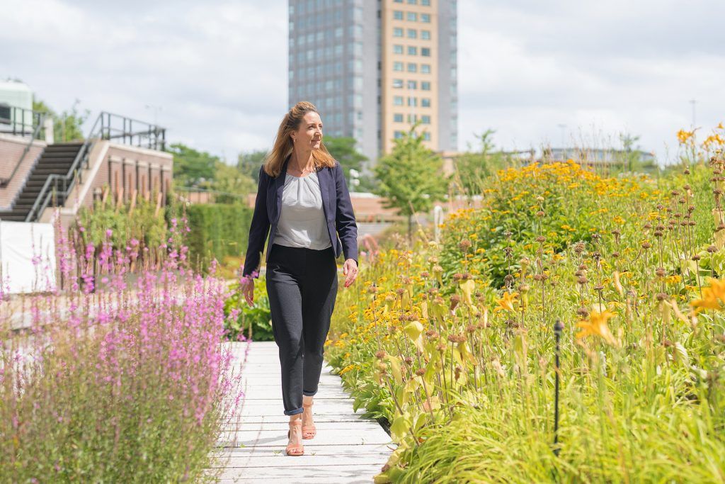 Woman in suit walks through flowering garden