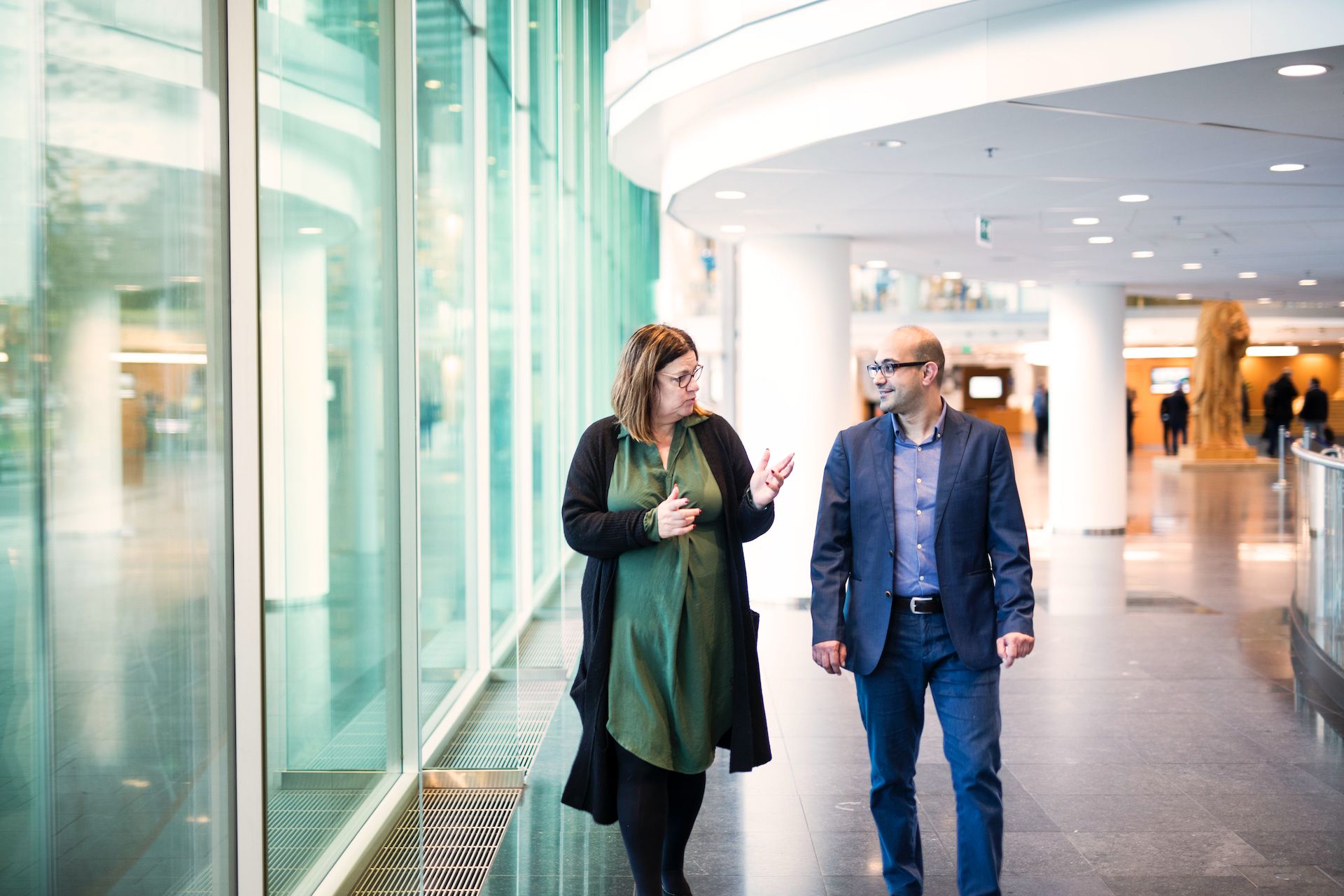 Ali Kaddourah en Anne-marie Breuker  lopen pratend door gang in Rabobank.
