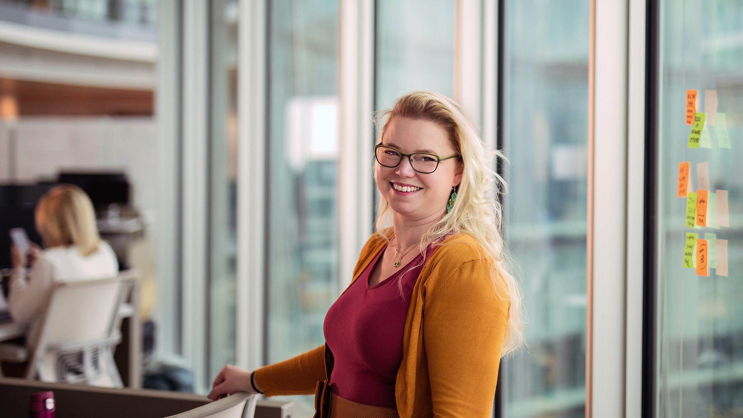 Renske Melchers van Wavemakers staat naast een bureau in een modern kantoor.