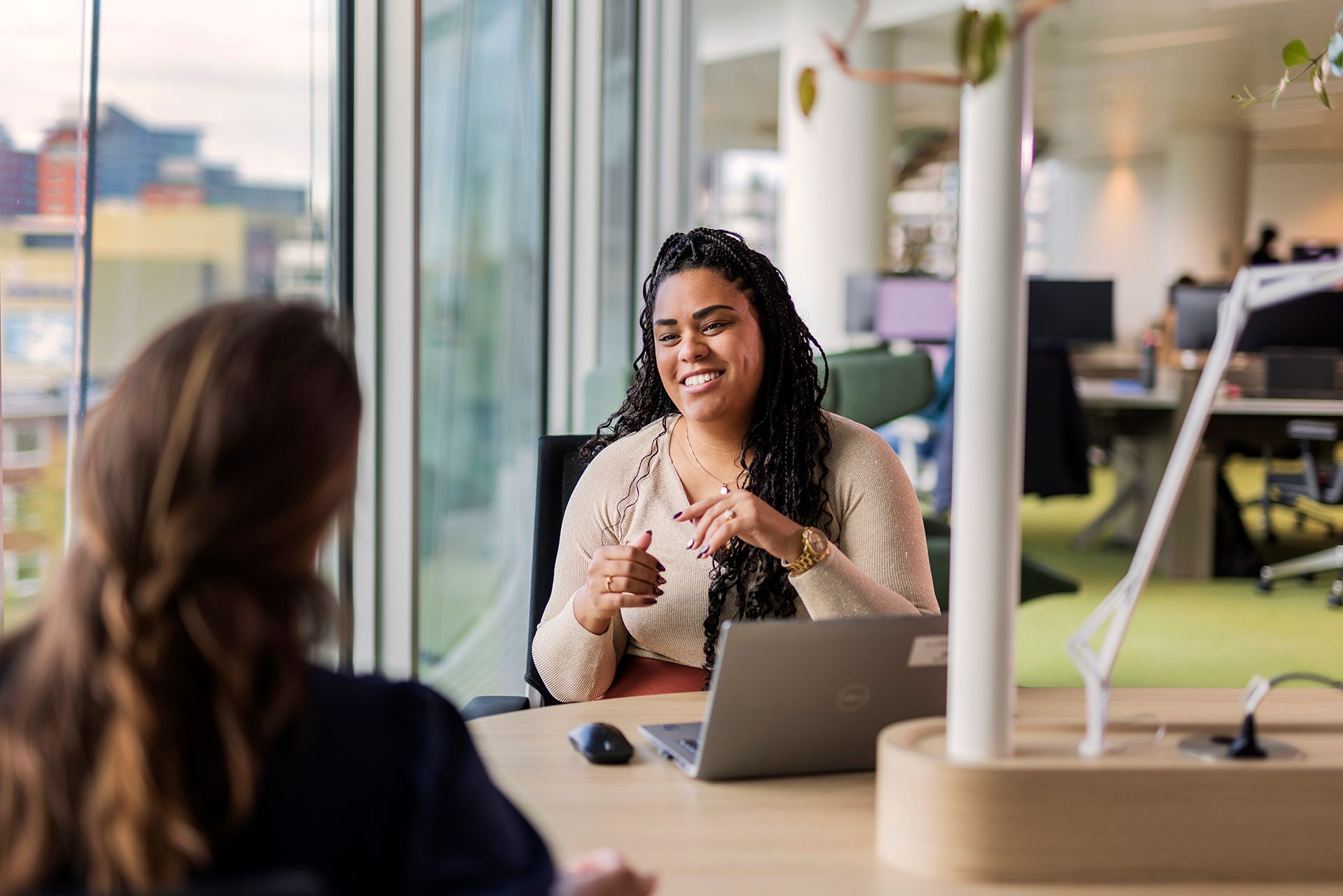 Dianara Verhoeven, Assistent Transaction Banker in gesprek met collega aan tafel met laptop