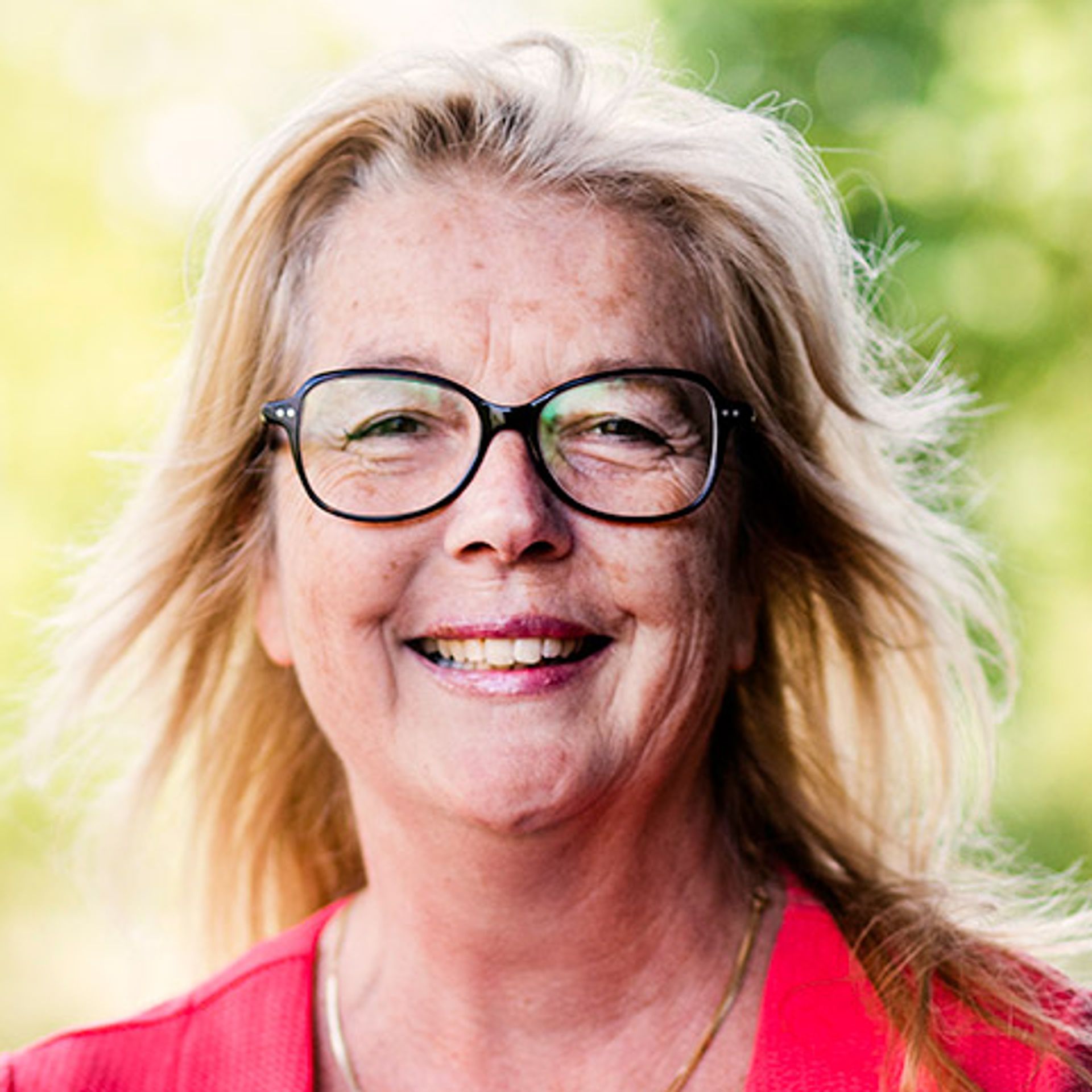 Carolien buiten naast gebouw in groene omgeving