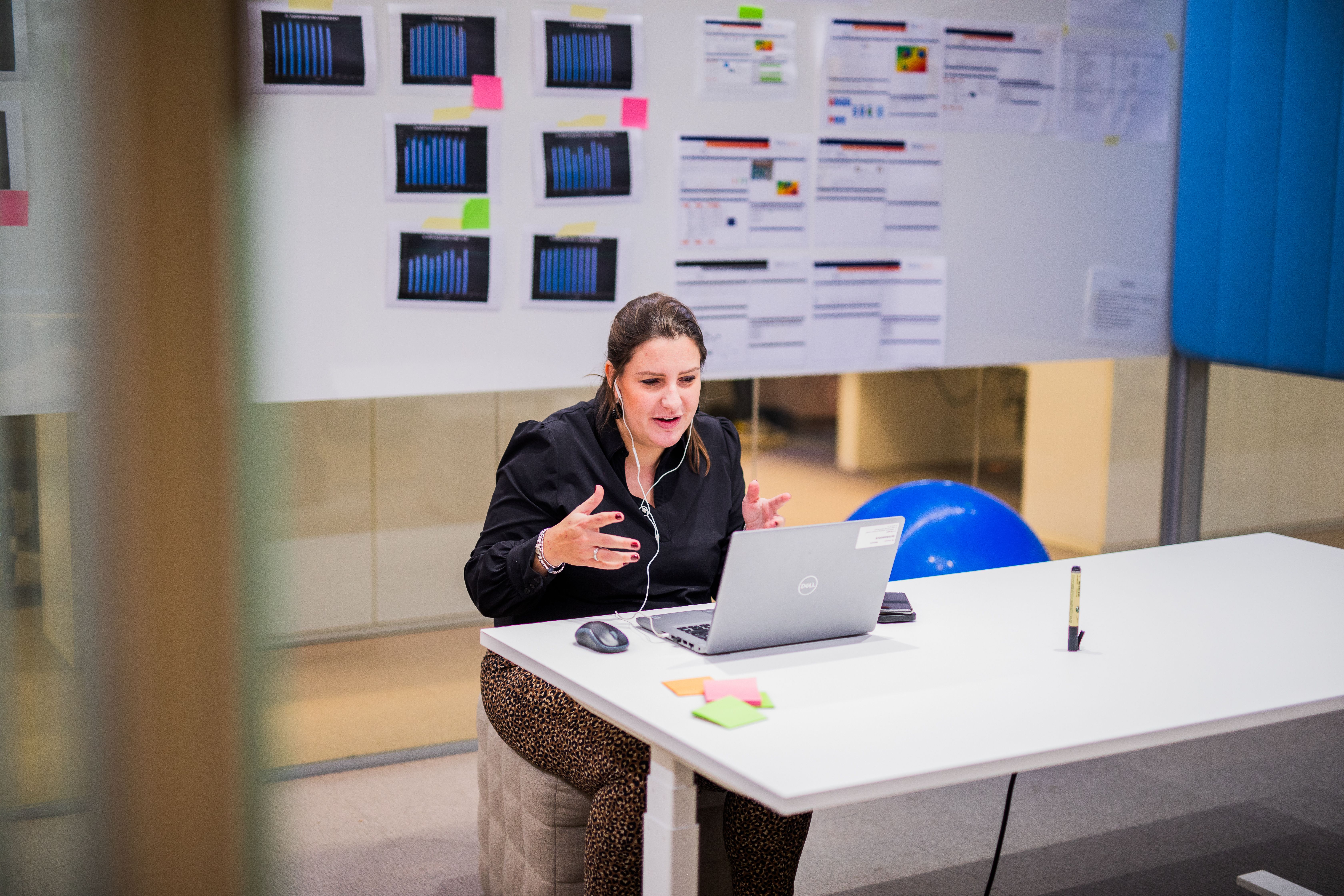 Woman sitting behind laptop.