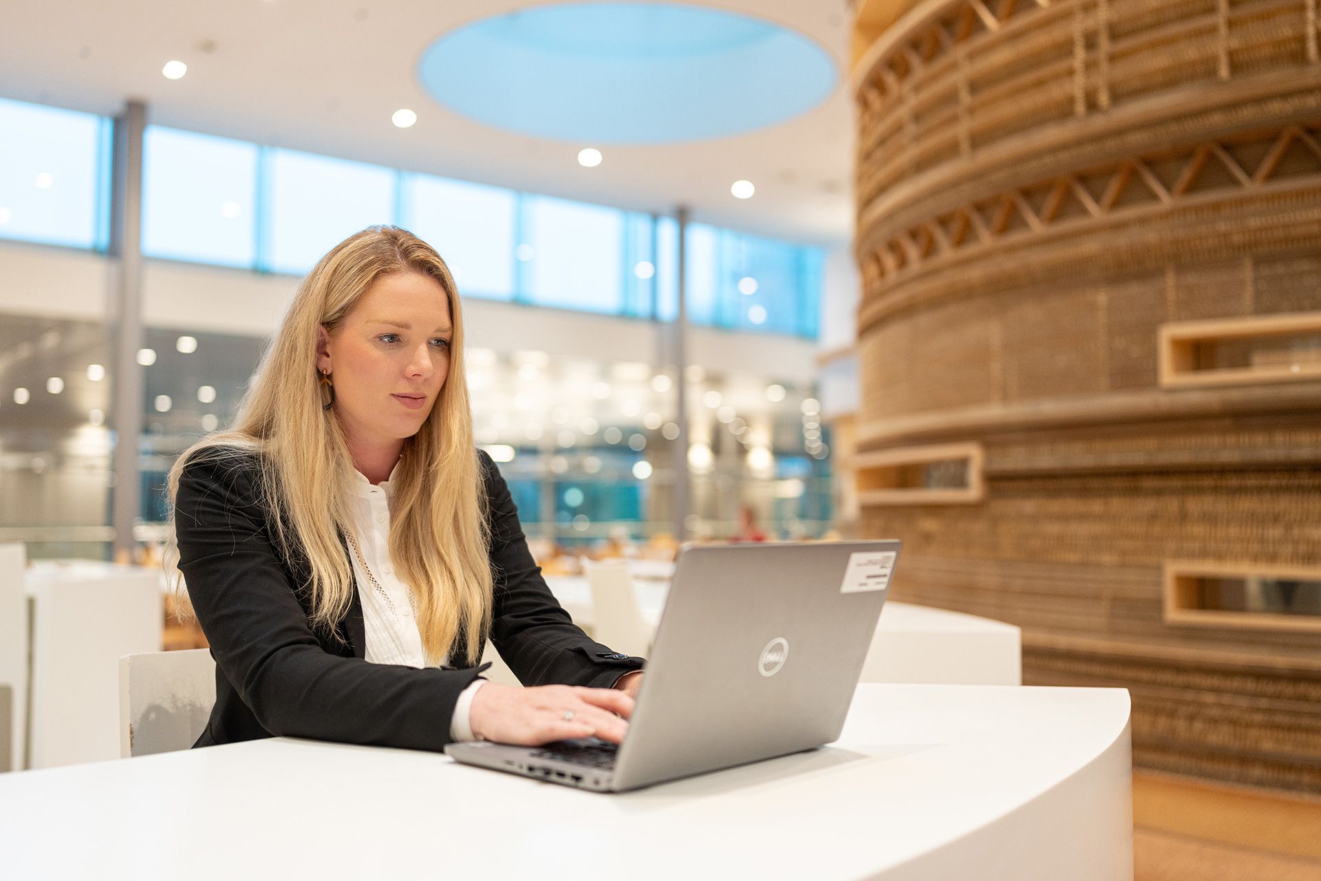 Vrouw aan het werk achter laptop.