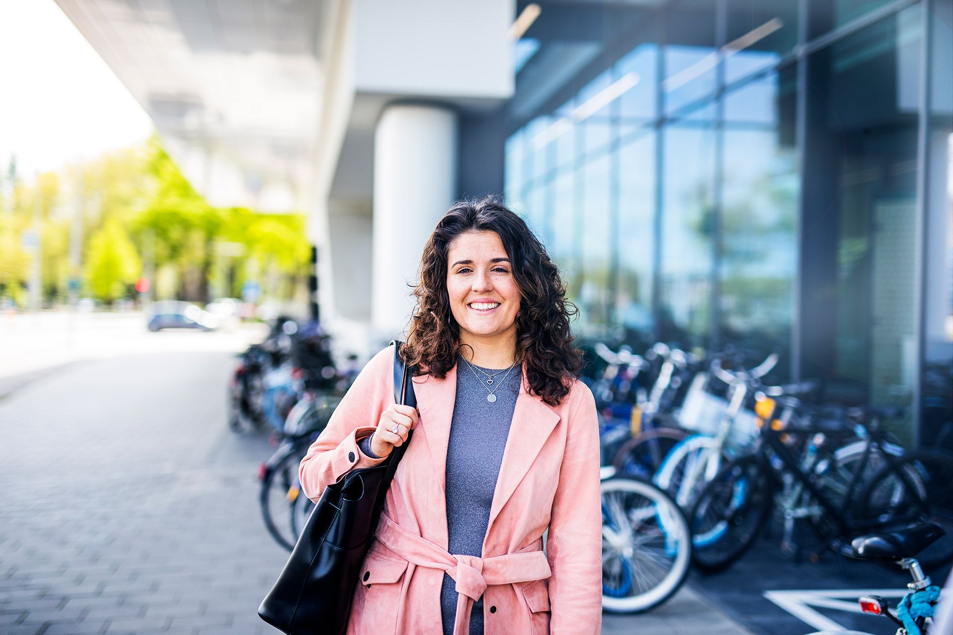 Vrouw voor modern gebouw (financieringsspecialist bij Rabobank)
