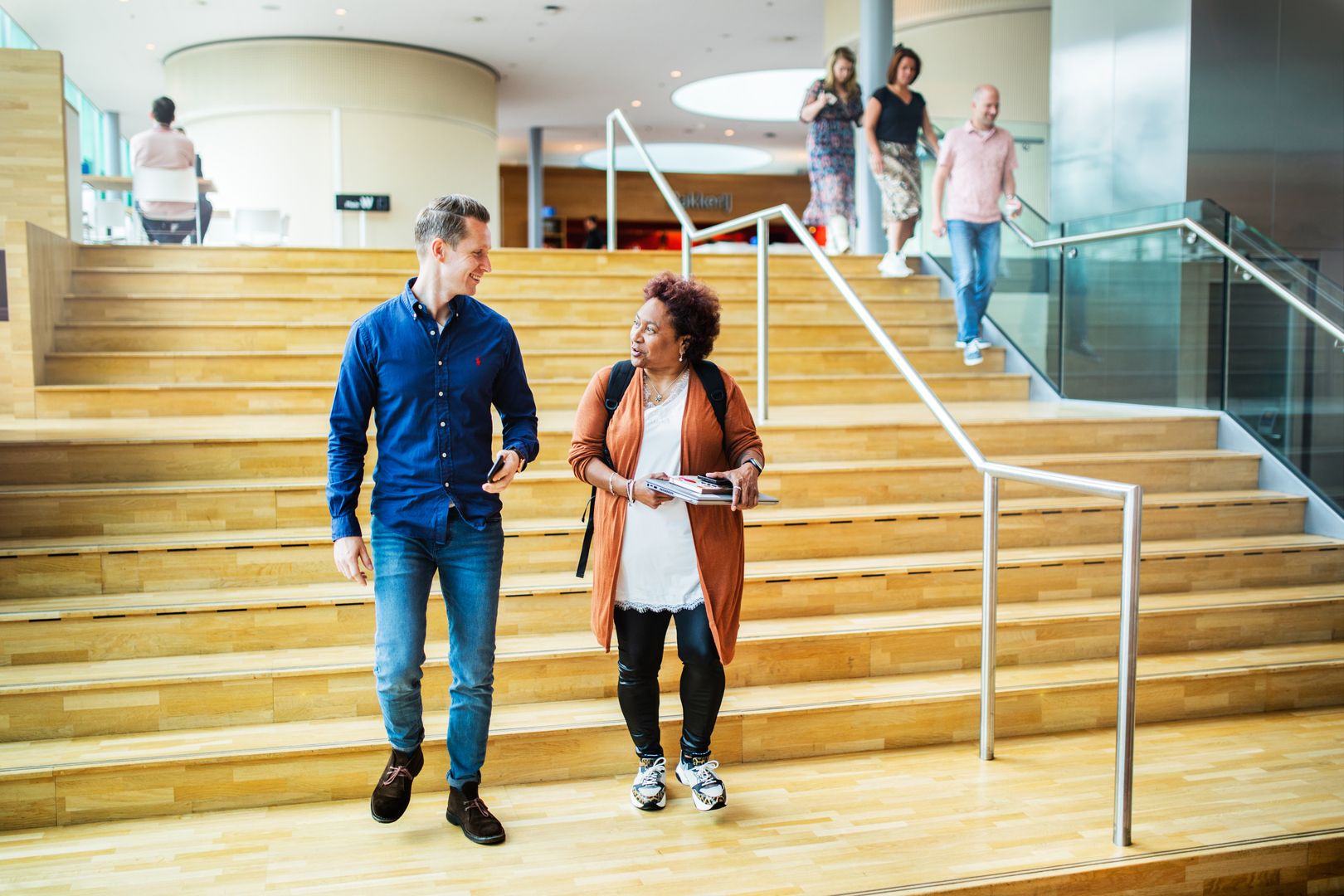 Man en vrouw in gesprek op trap.