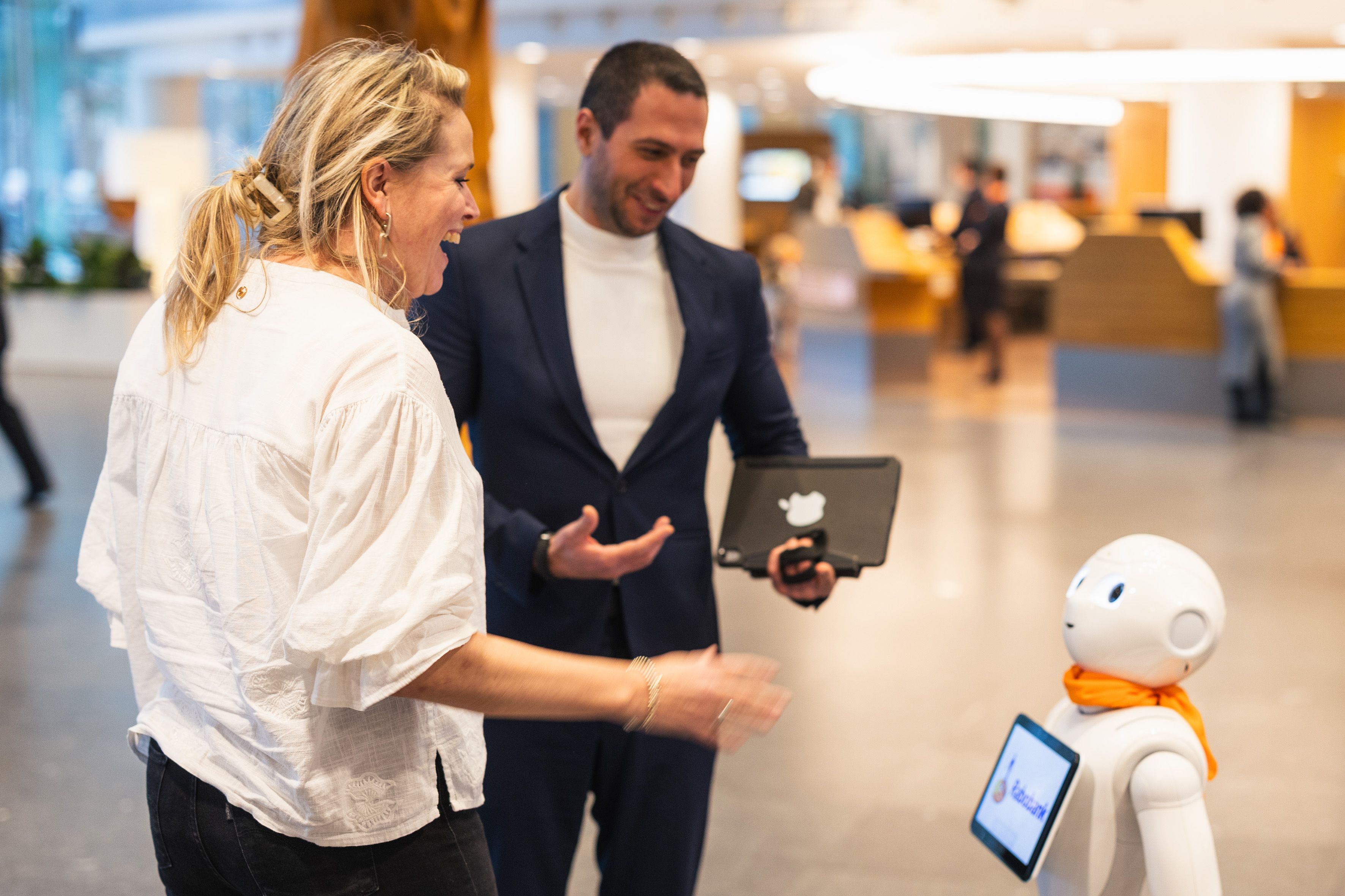 Man en vrouw lachen naar robot