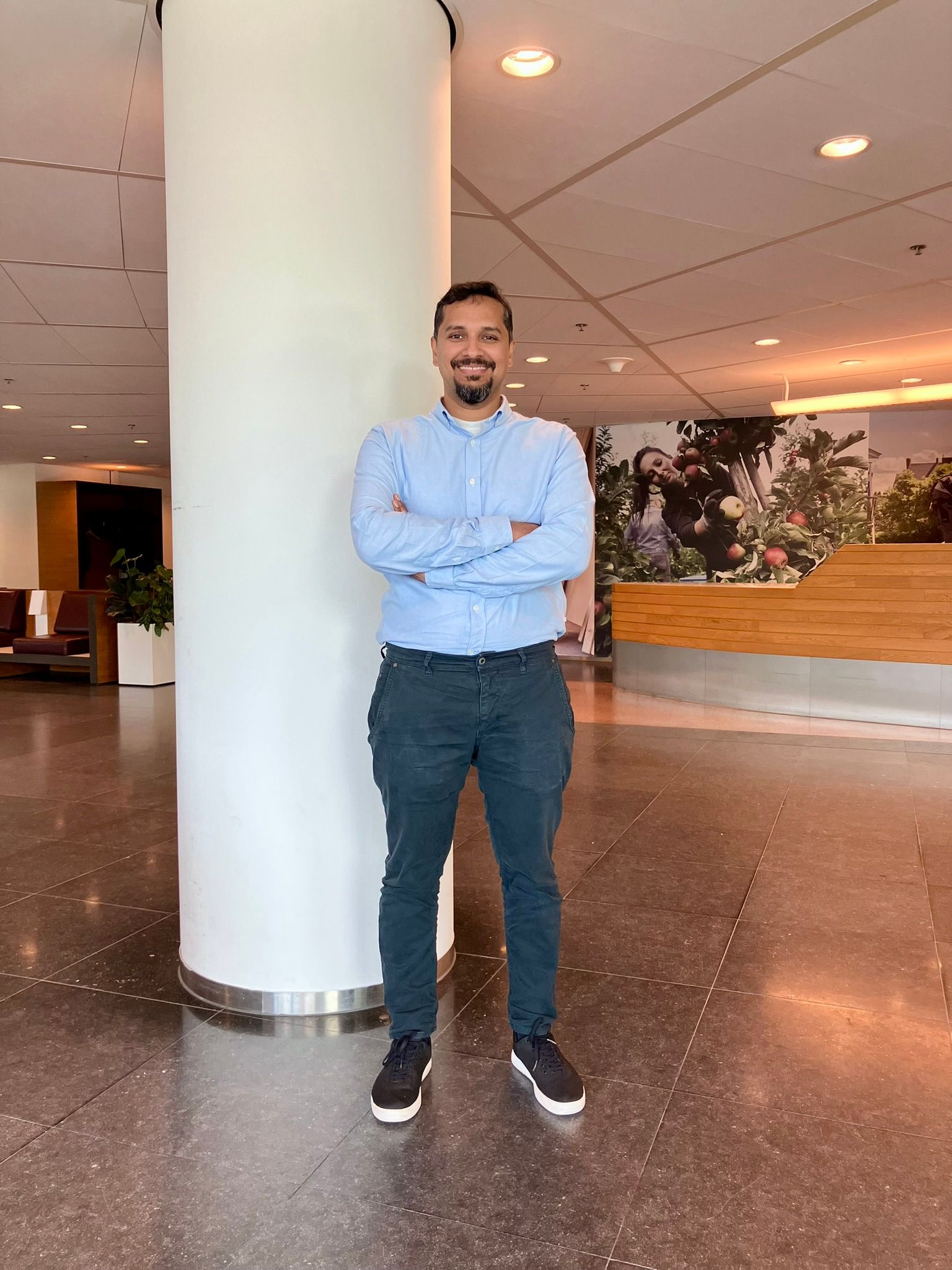 Man wearing a blue blouse at the office