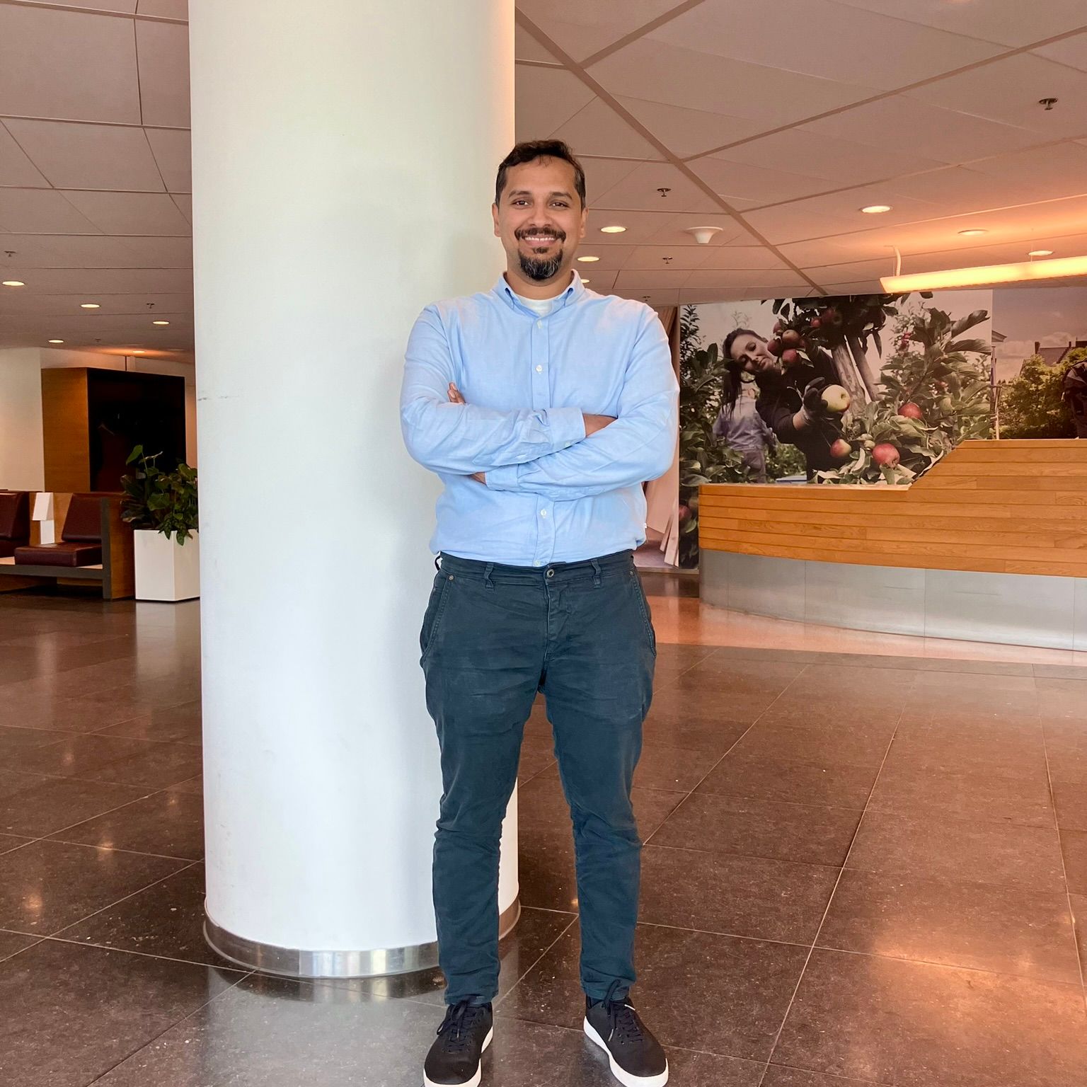 Man wearing a blue blouse at the office
