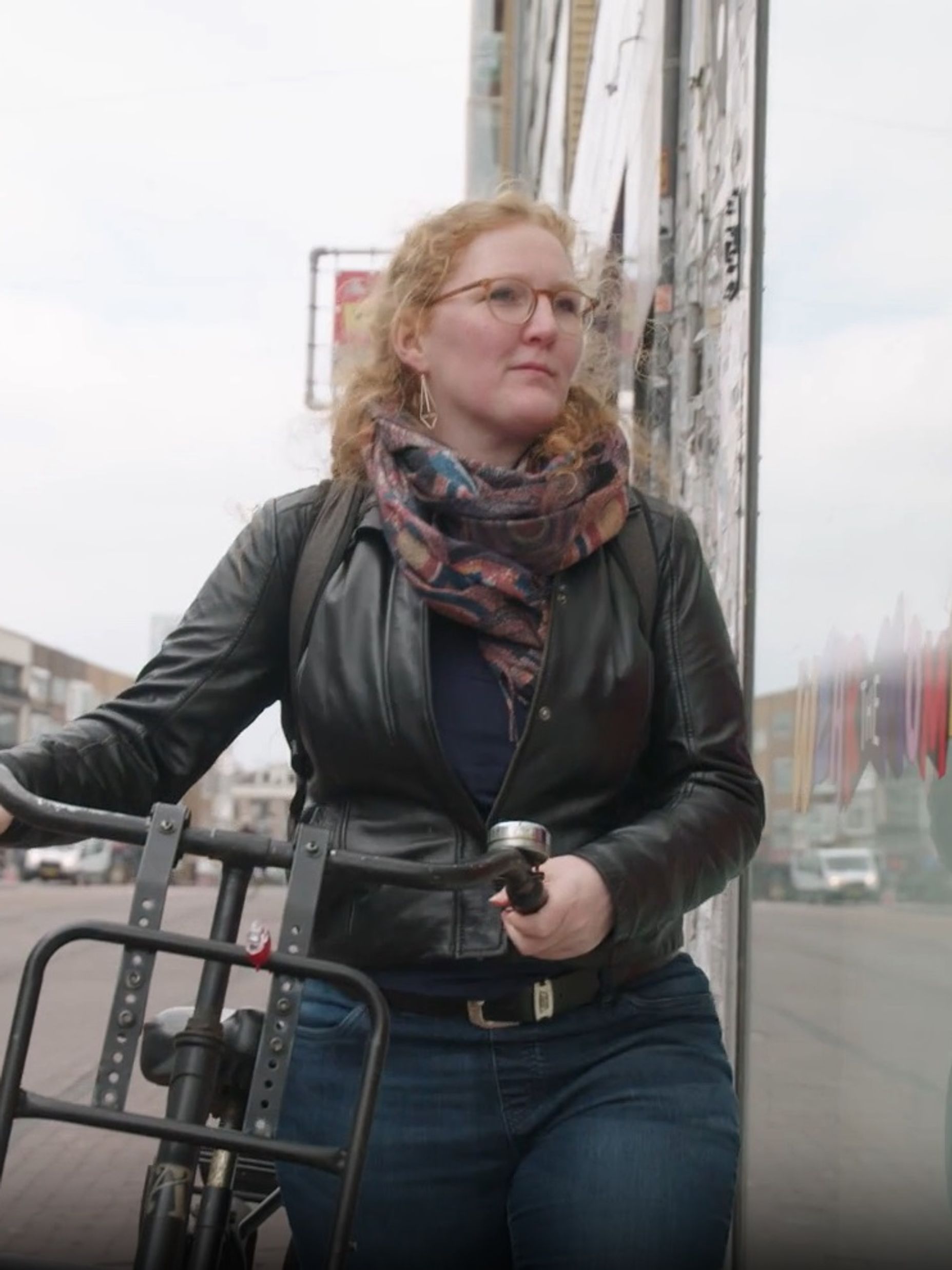 Vrouw loopt met fiets aan de hand door winkelstraat