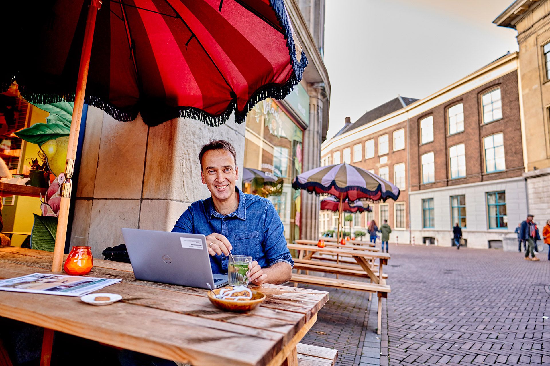 Martin Dijkman op terras met laptop en kop muntthee
