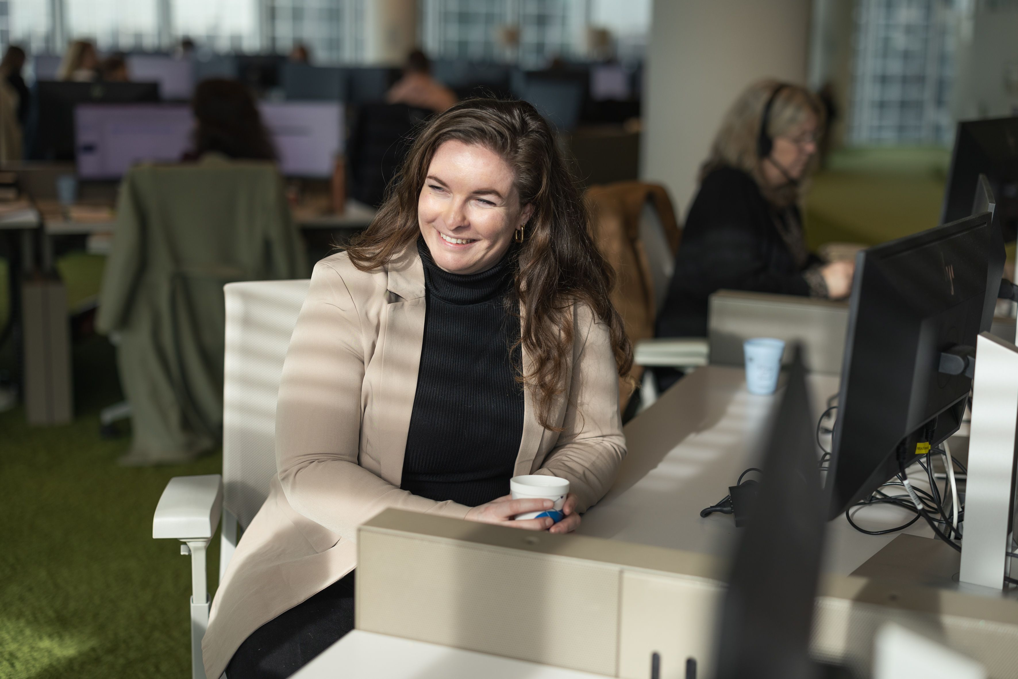 Vrouw achter bureau aan het werk en kijkt opzij
