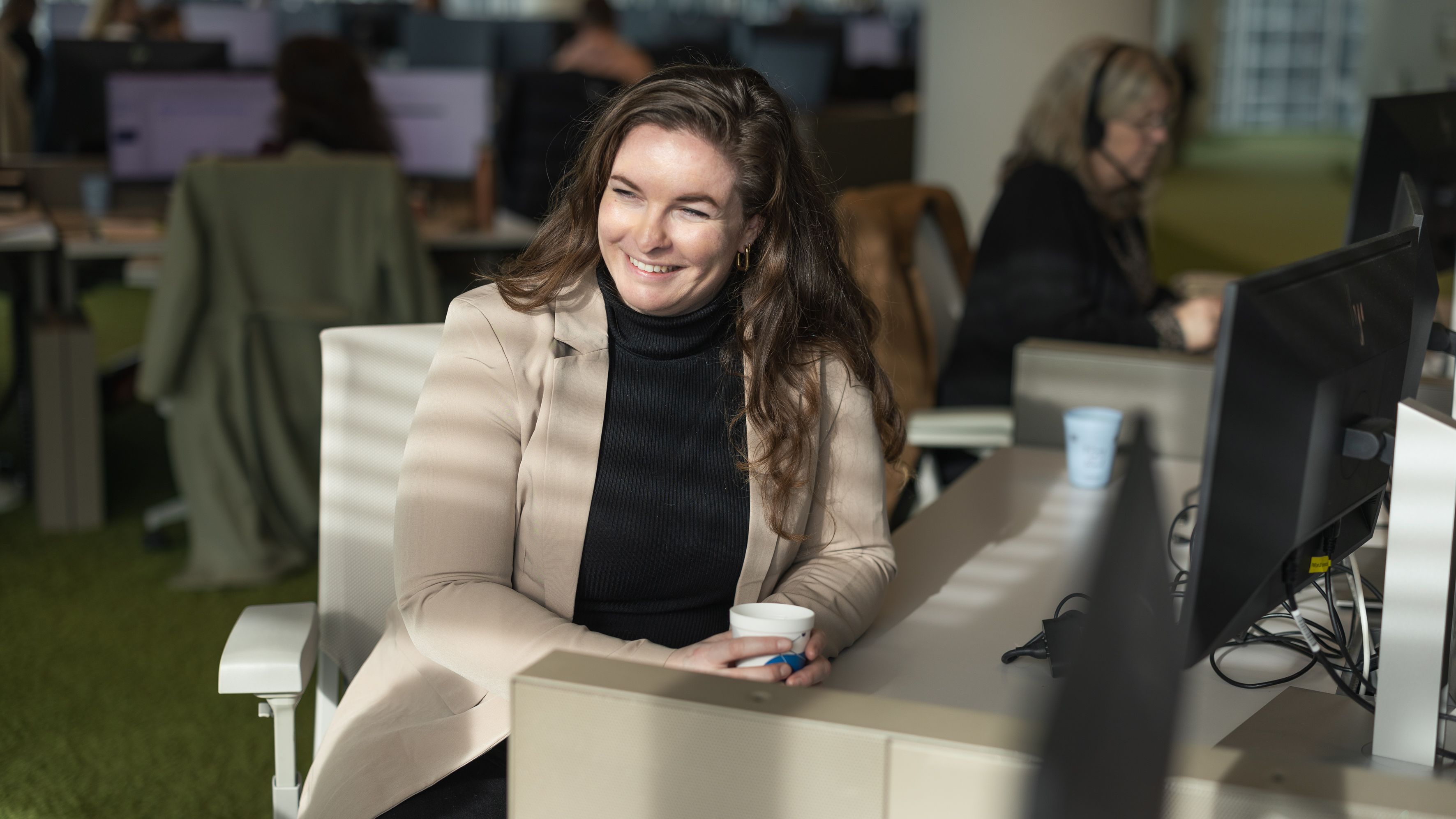 Vrouw achter bureau aan het werk en kijkt opzij