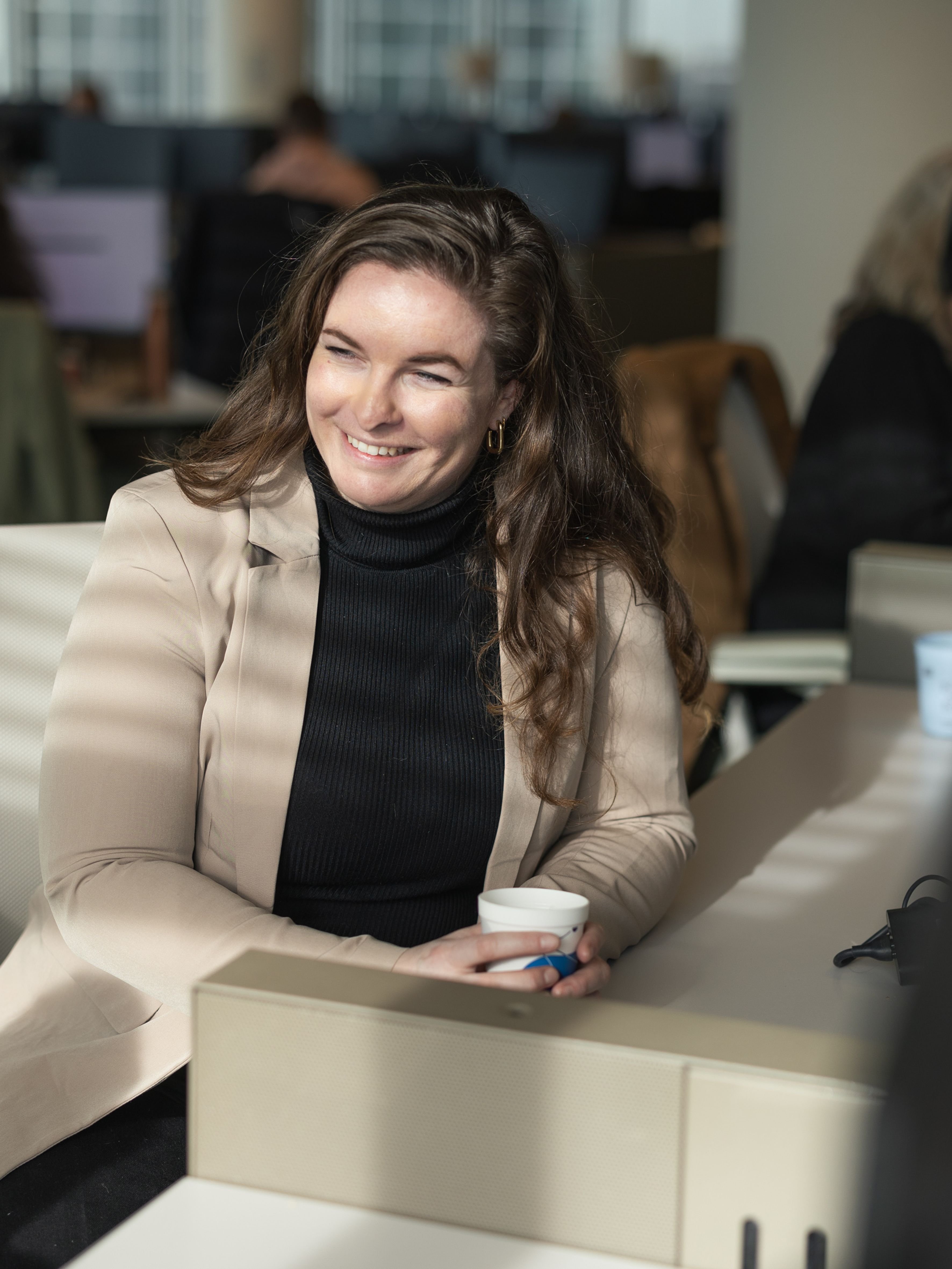Vrouw achter bureau aan het werk en kijkt opzij