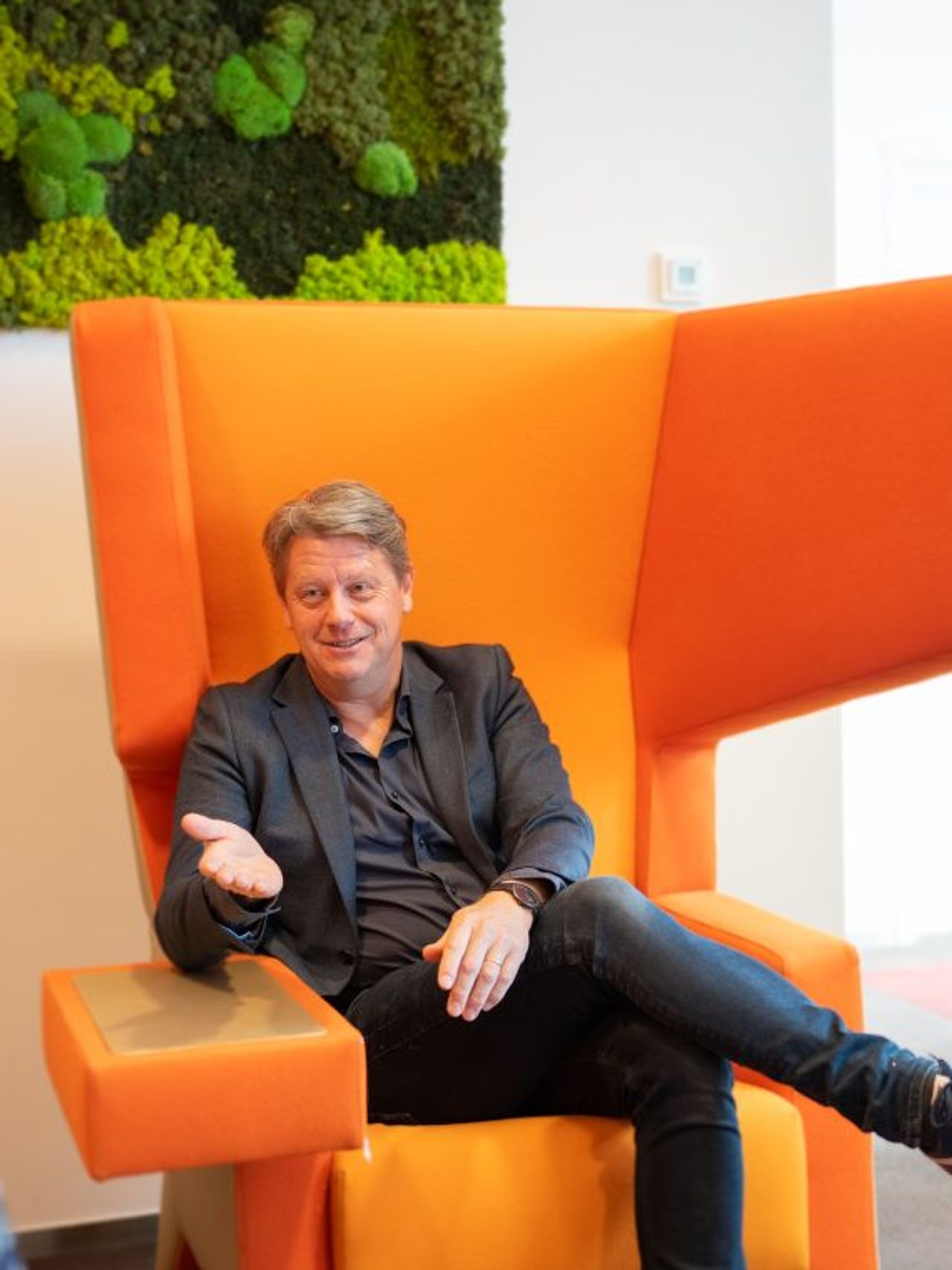 Man zit in een oranje stoel te praten met een vrouw