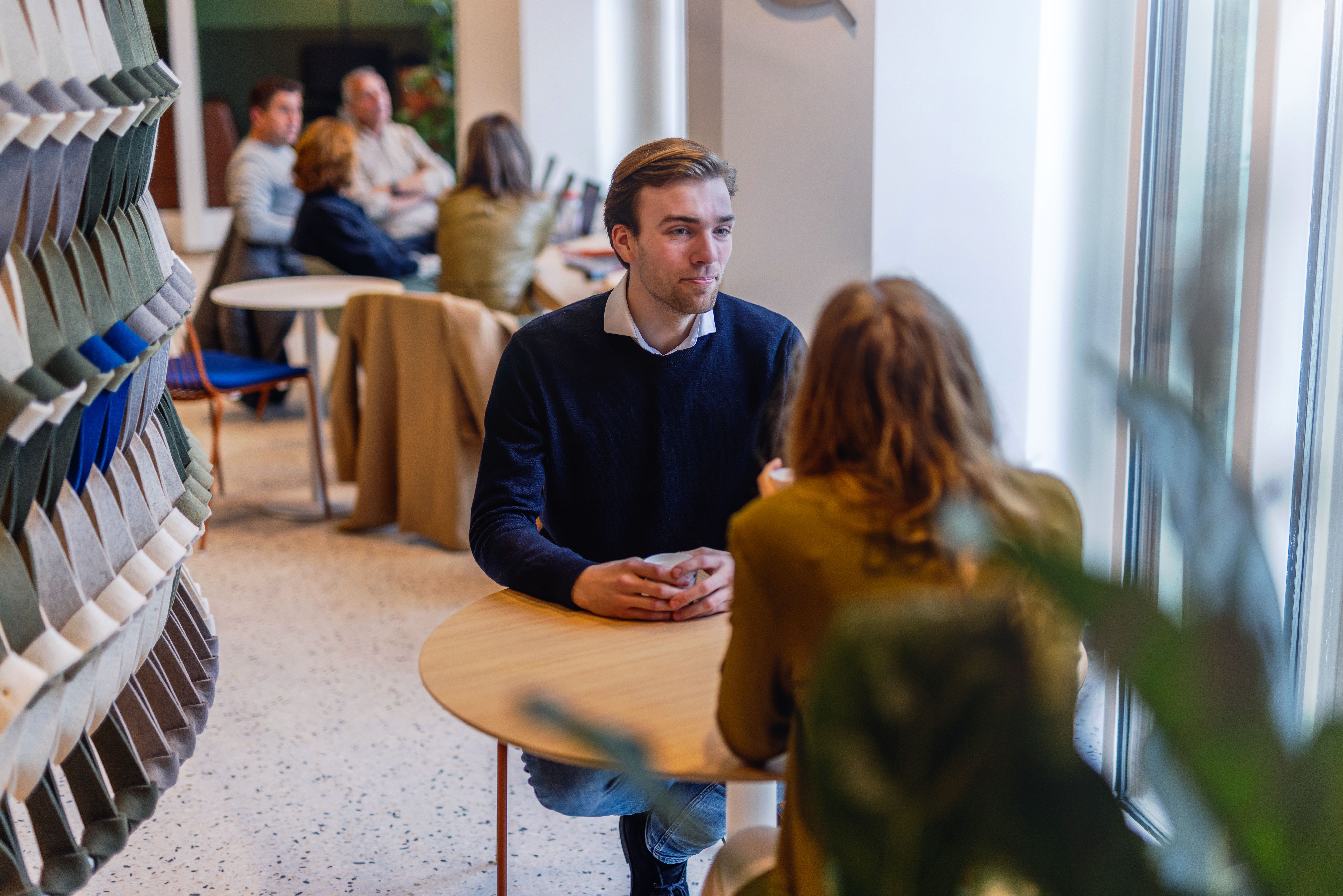 A male colleague is having a coffee with a female colleague