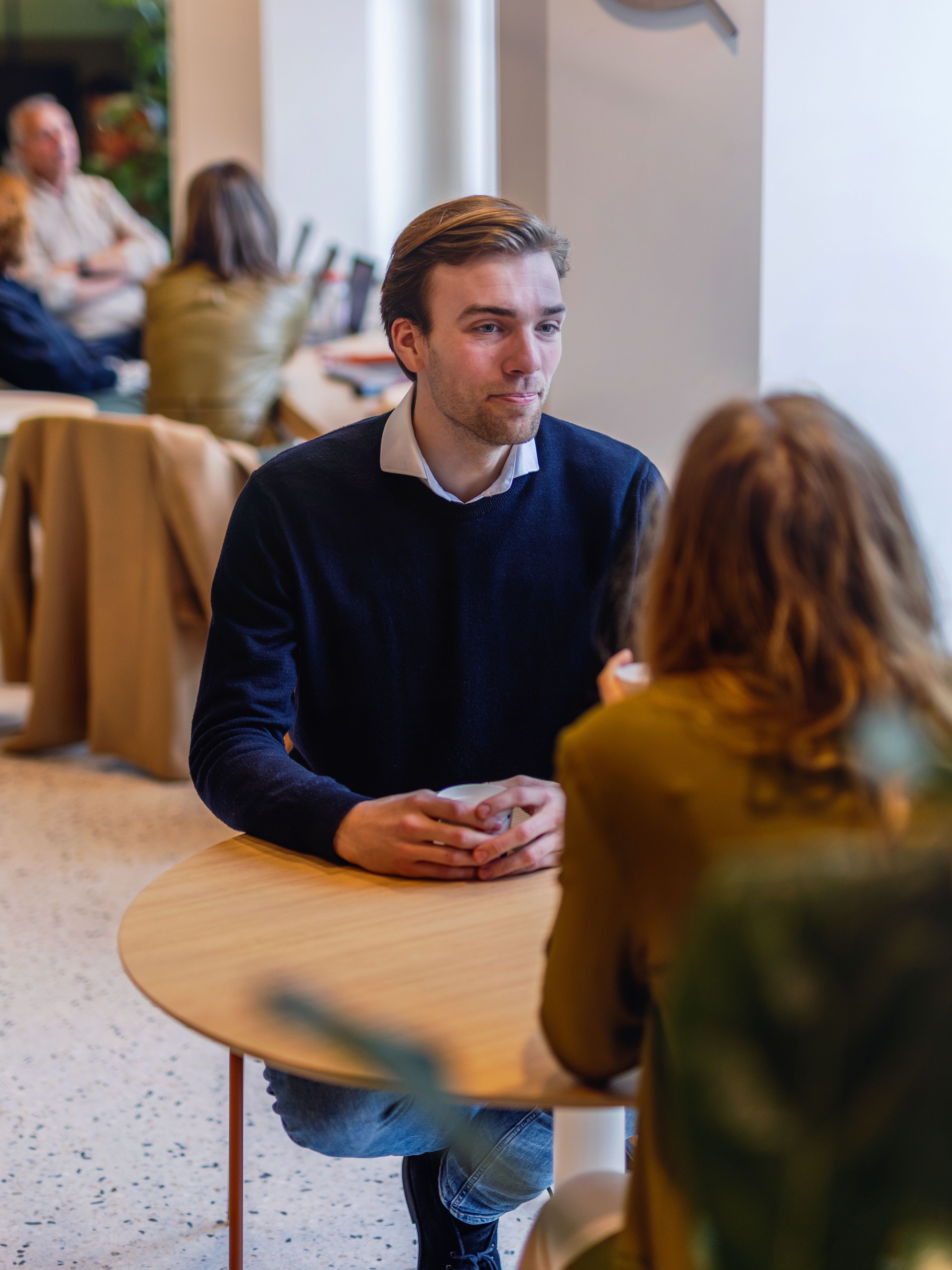 A male colleague is having a coffee with a female colleague