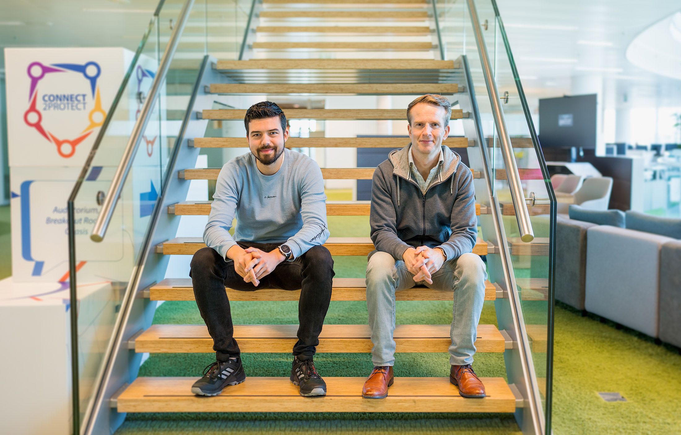 Luc en Neal sitting on the stairs in the office